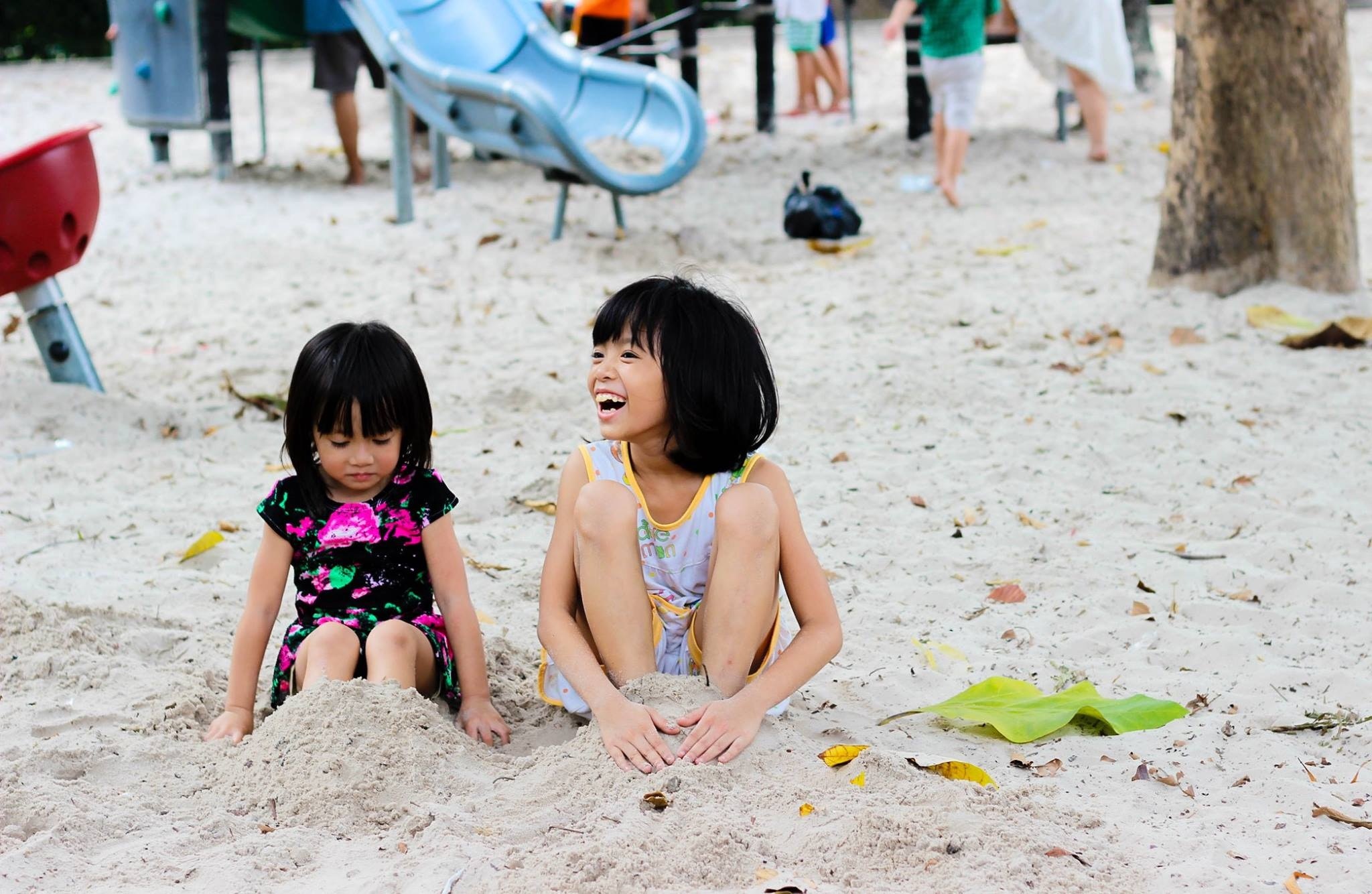 2 girls sitting on seashore photo