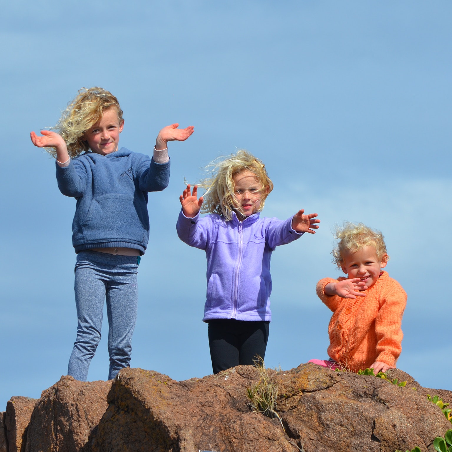 3 kids standing on rock photo