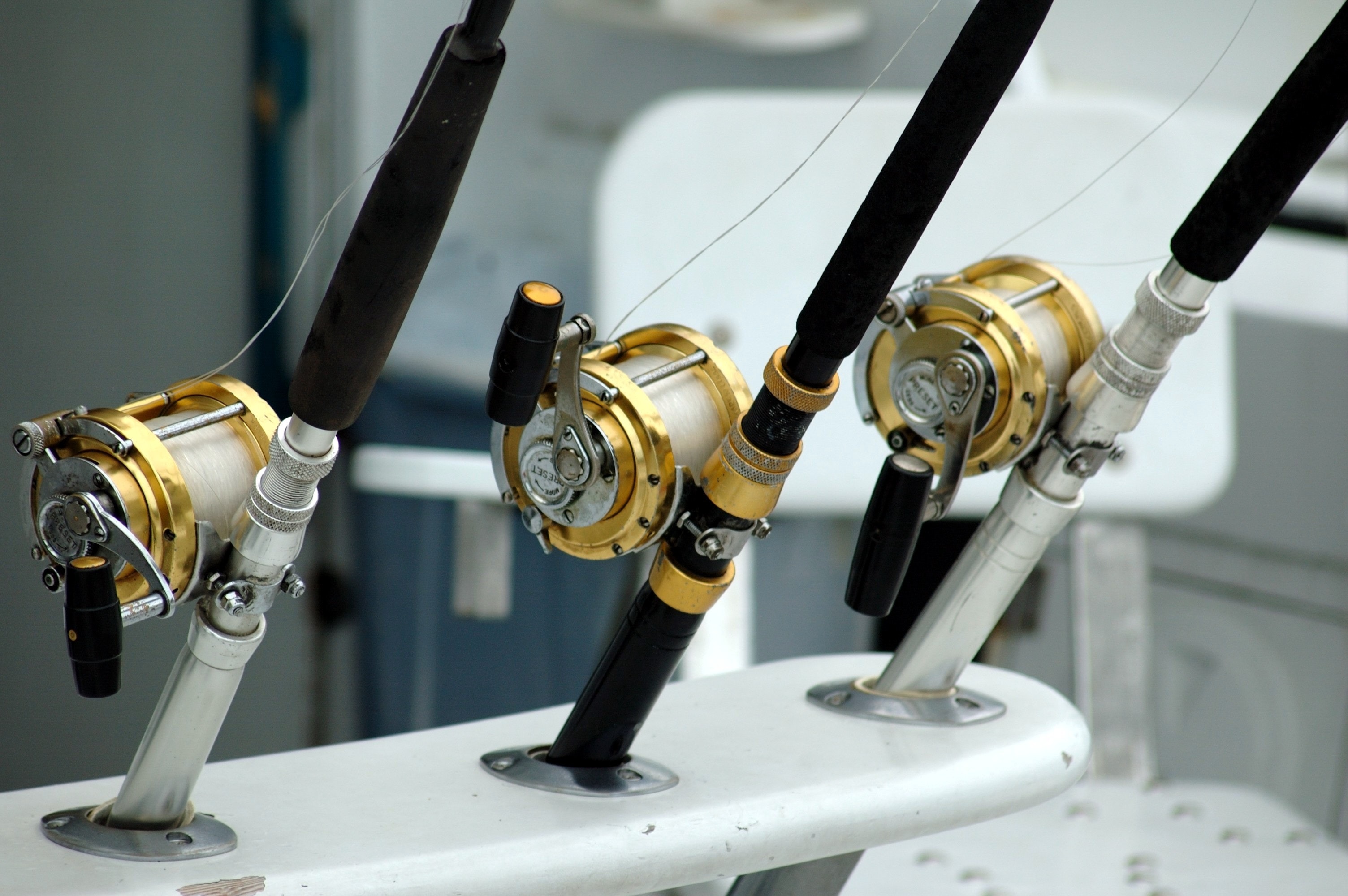 3 lined brass and black fishing reel photo