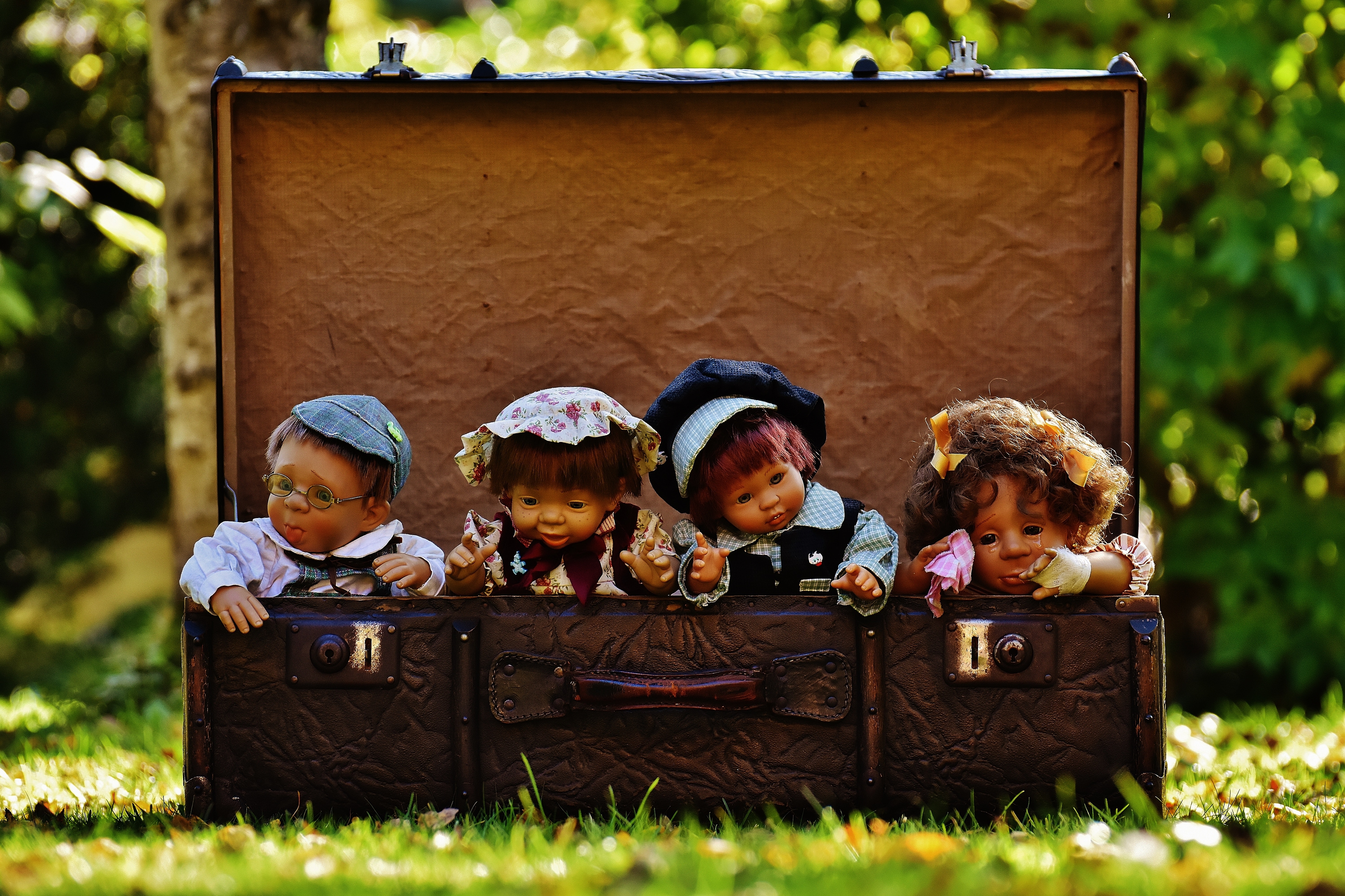 4 porcelain dolls in brown rectangular box photo