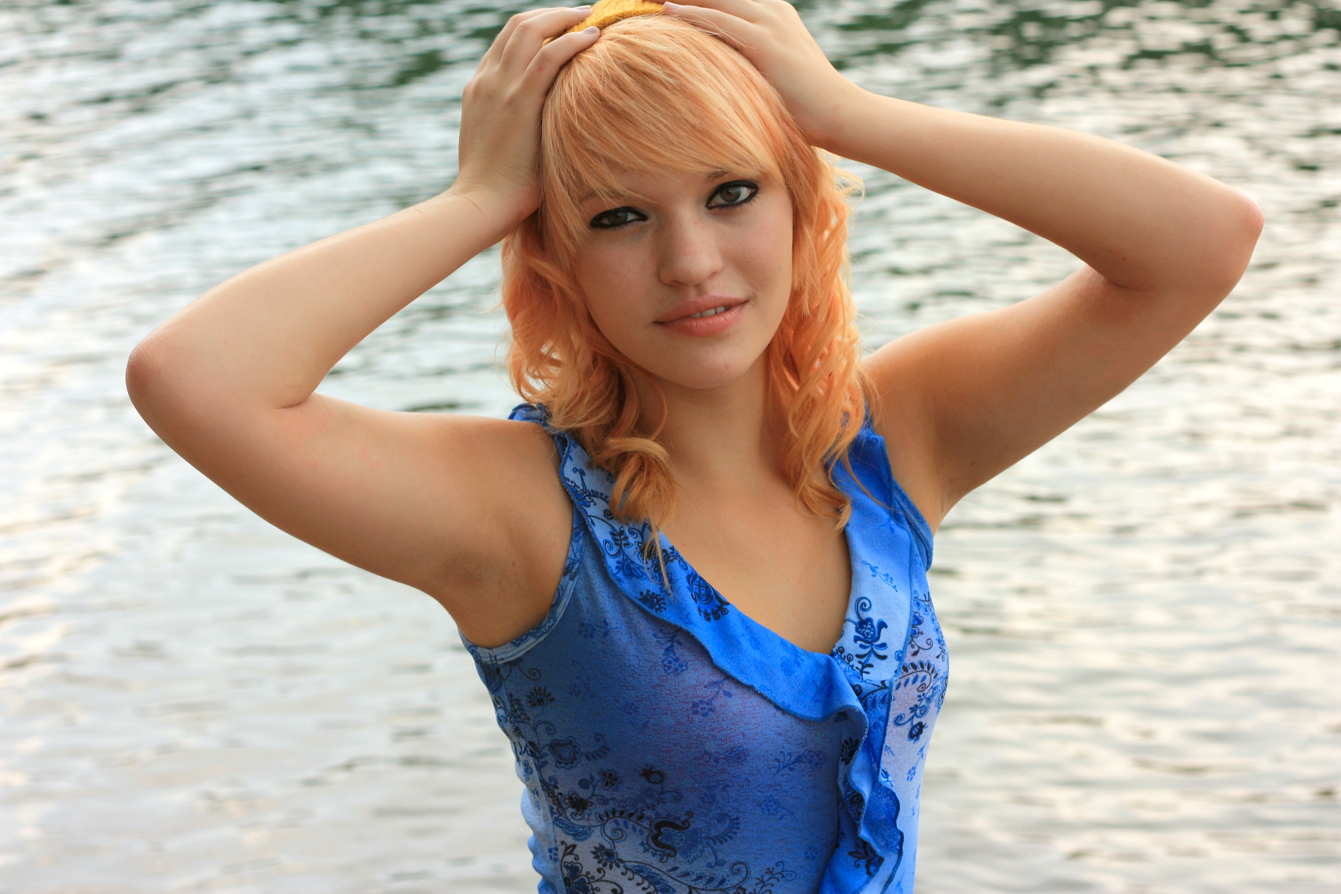 A beautiful young woman posing by a lake photo