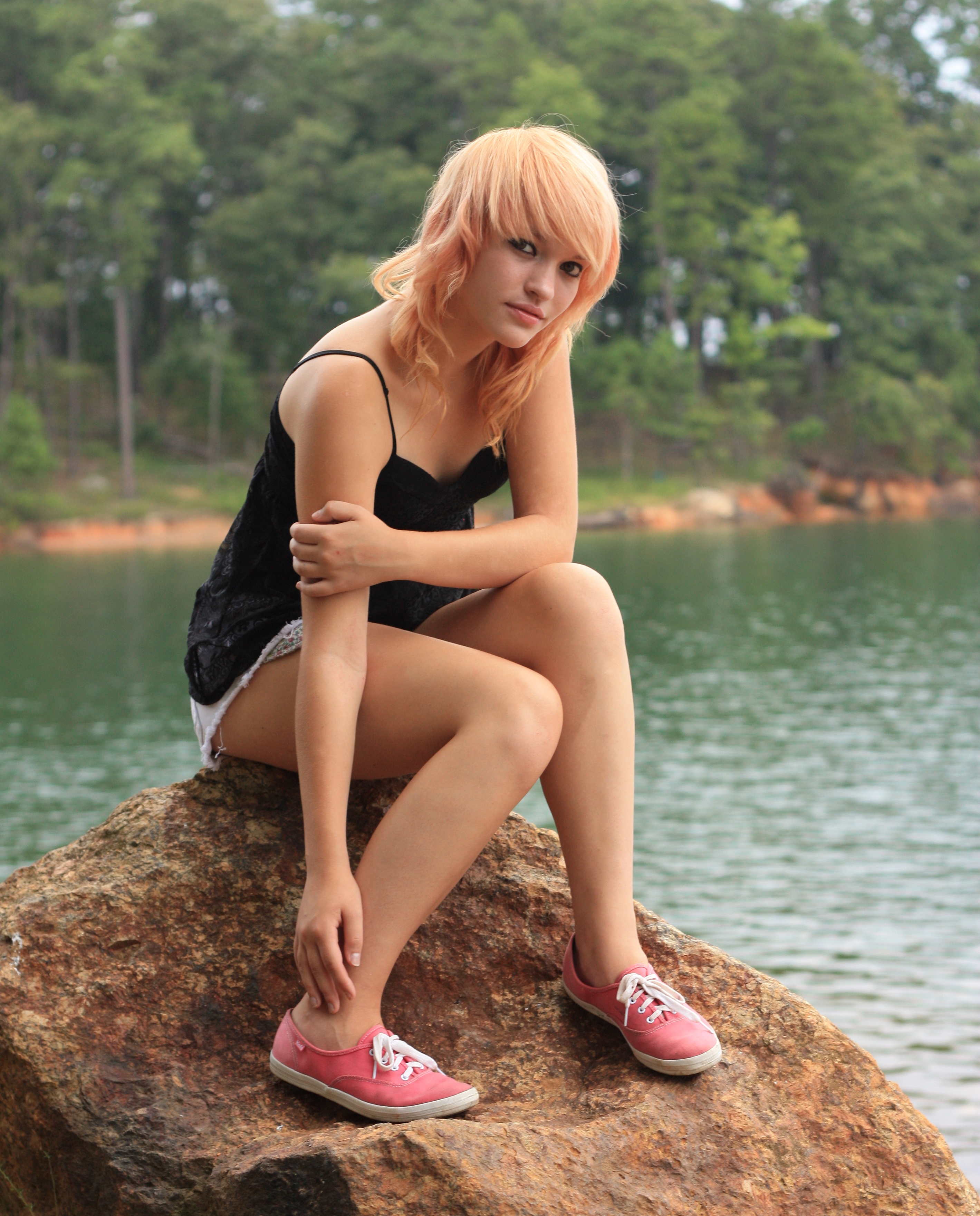 A beautiful young woman posing on a rock photo