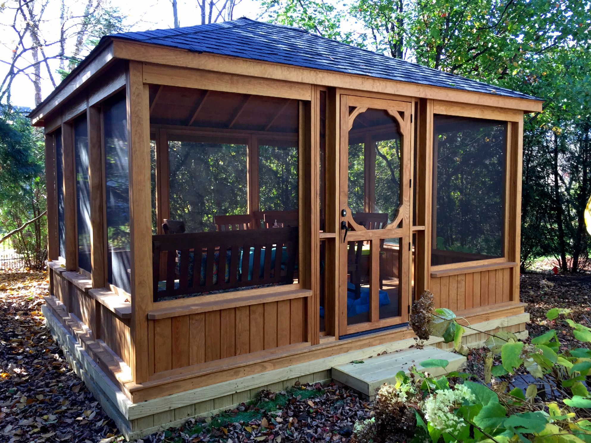 This gazebo features a low knee wall and large screened walls ...