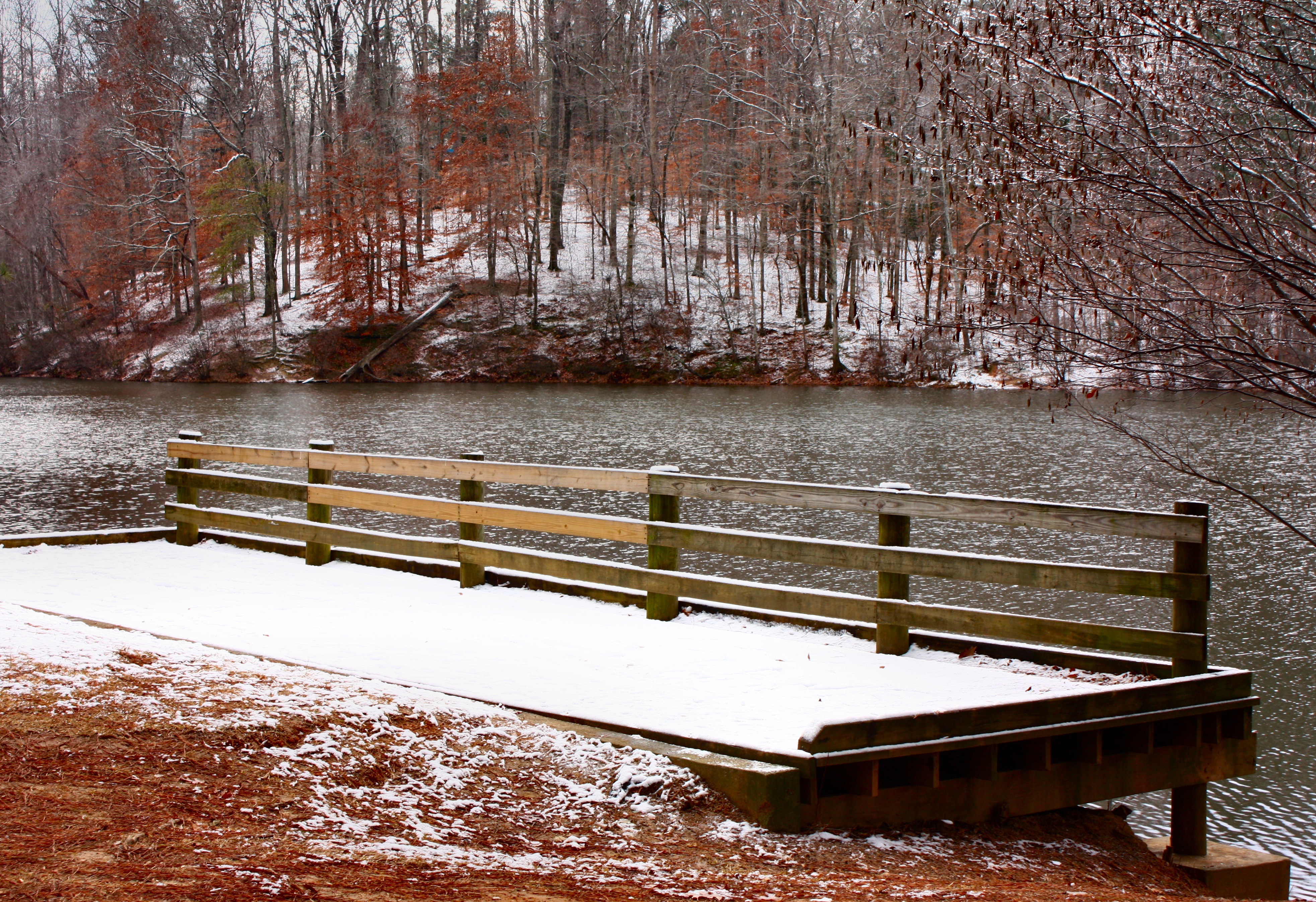 A snow covered dock by a lake photo