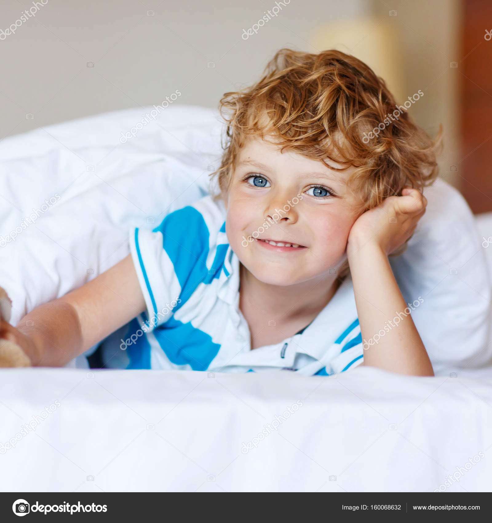 Adorable kid boy after sleeping in his white bed with toy — Stock ...
