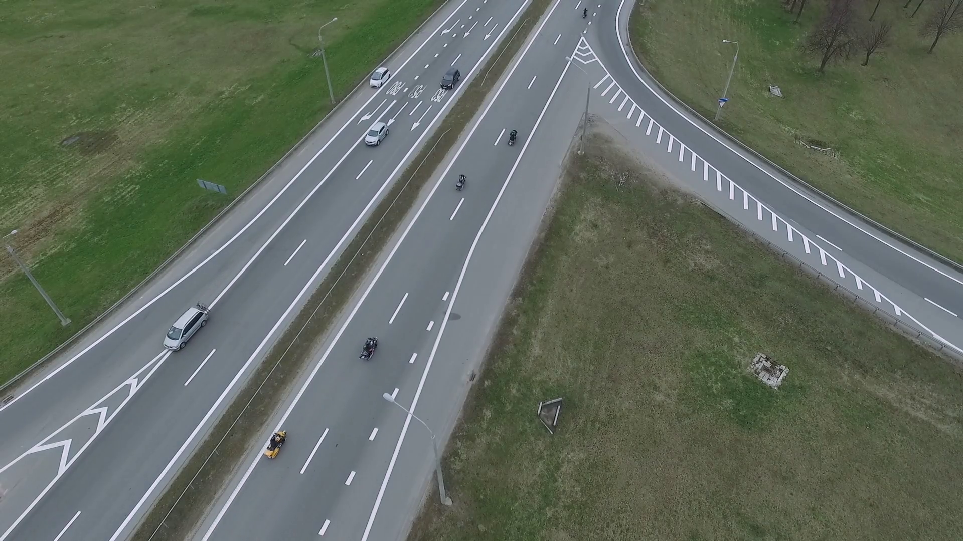 Aerial view from the height to the road, bikers drive on the highway ...
