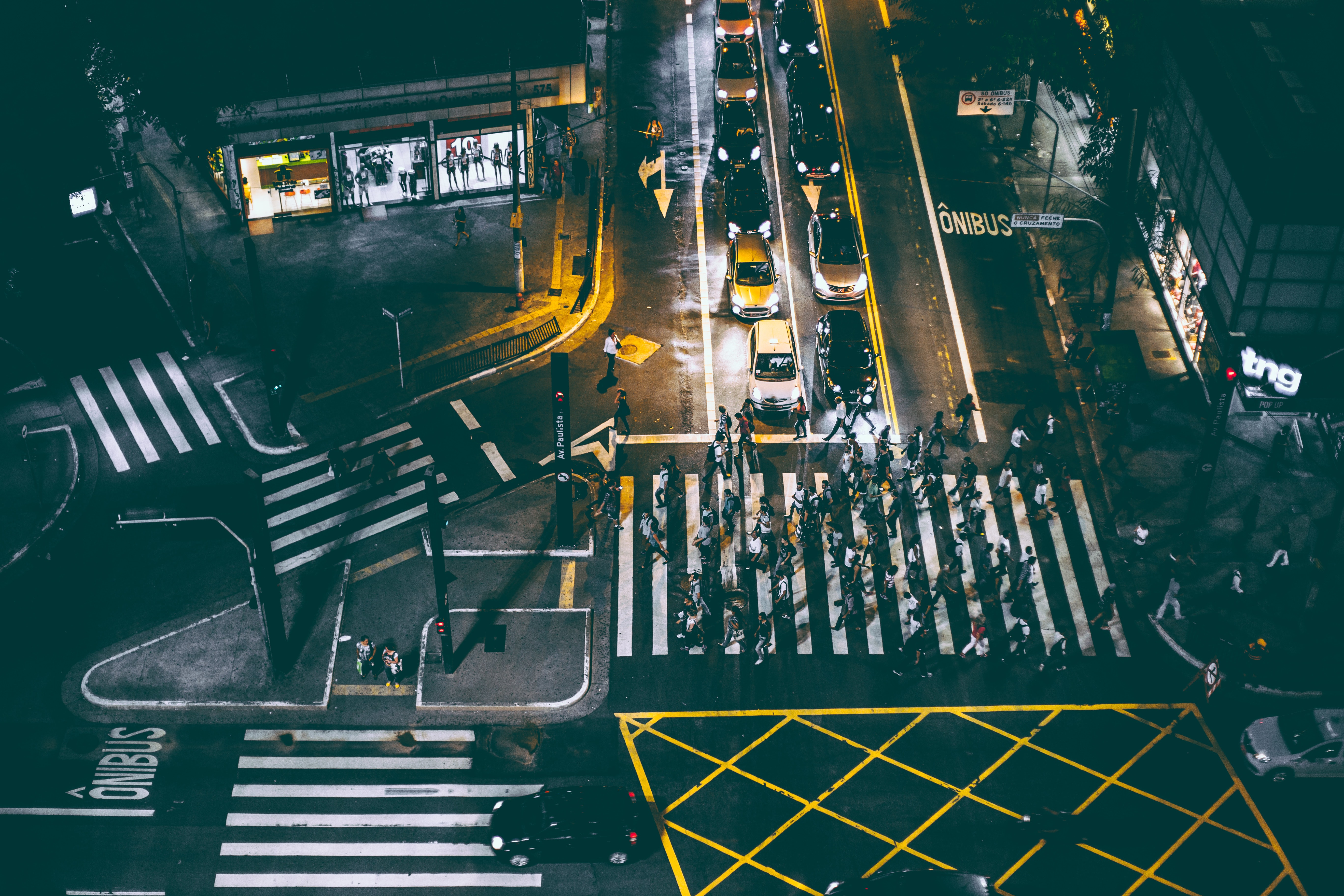 Aerial view of bunch of people walking on white pedestrian lane during night photo
