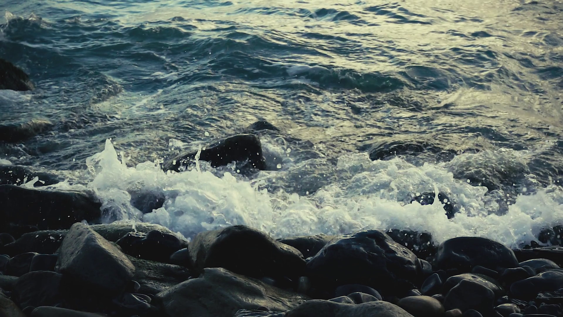 Slow motion waves breaking against rocks on the shore, move the ...