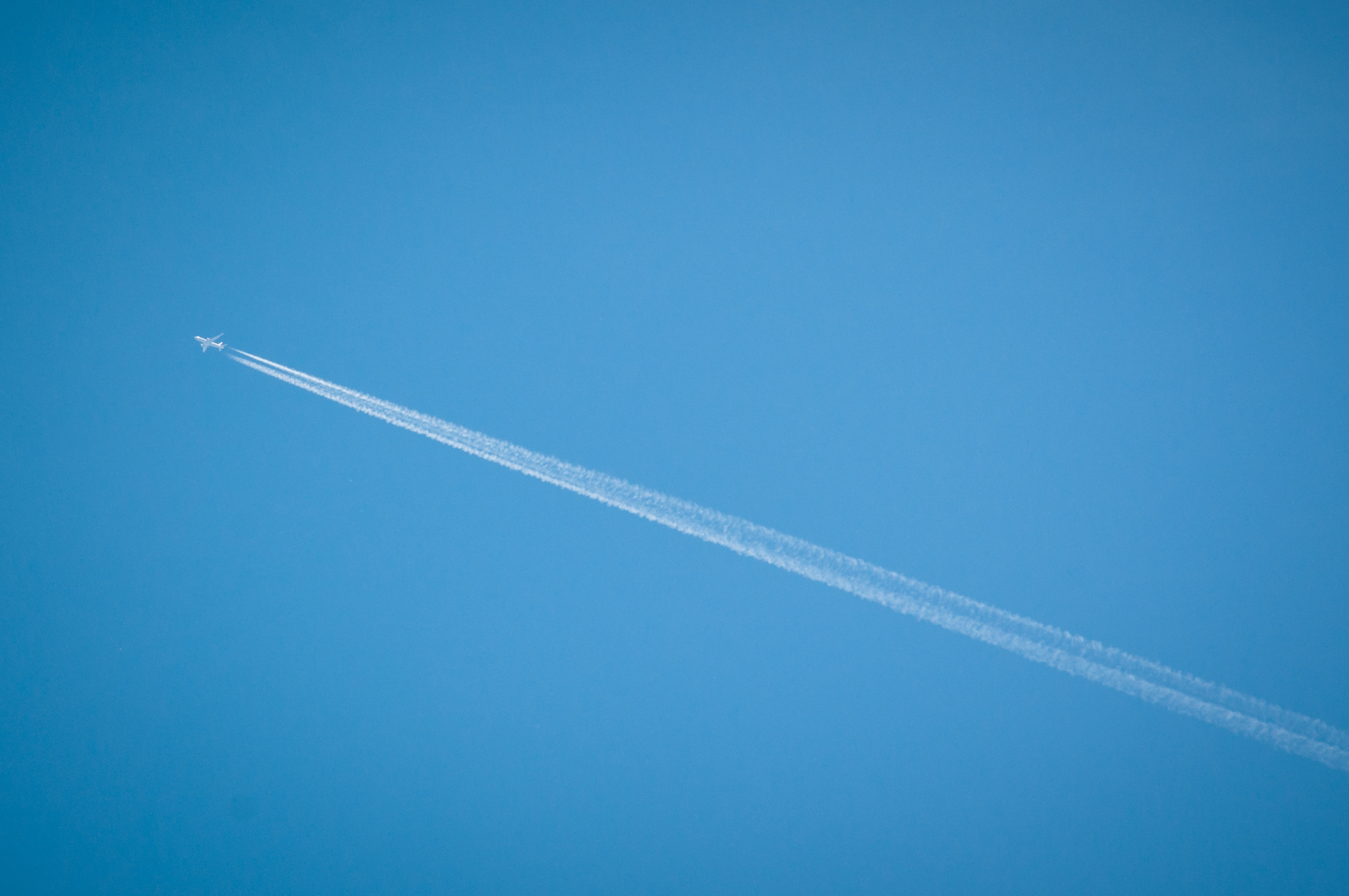Airplane flying through blue sky photo