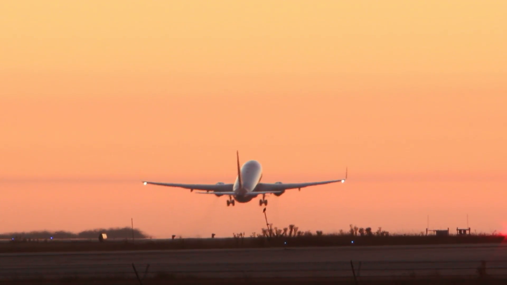 HD footage of a twin engine plane taking off in silhouette against ...
