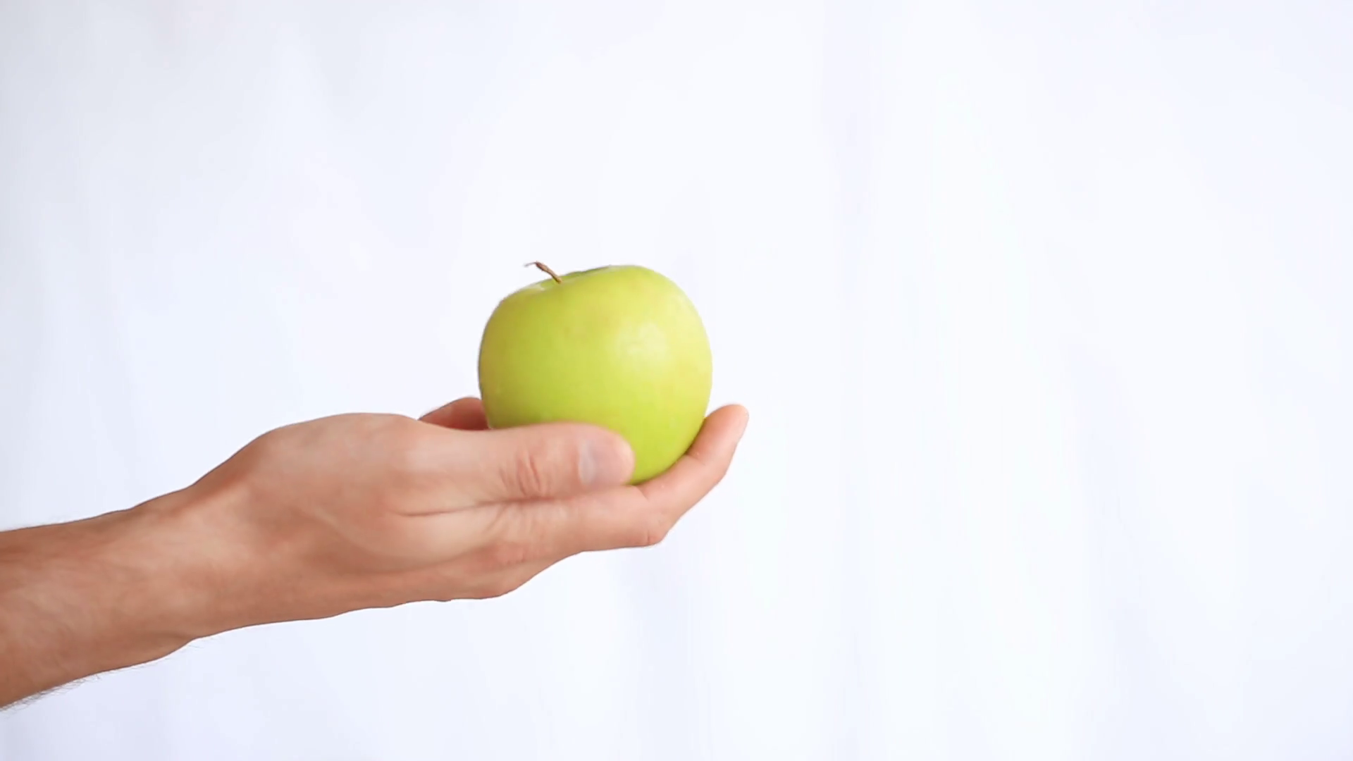 Man's hand holds fruit on a white background. green apple Stock ...
