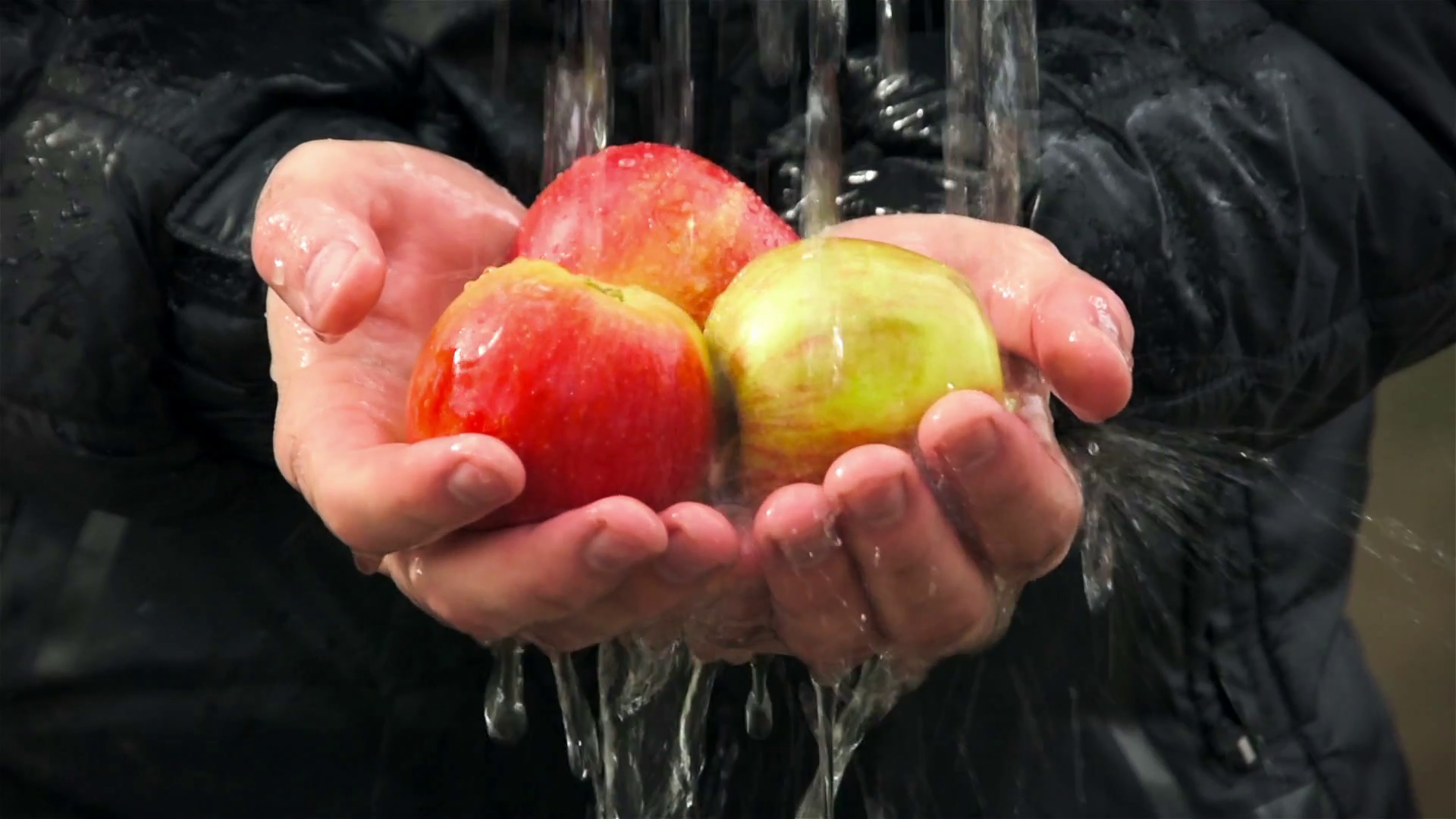 Water flows on fresh apples in hands of man. Vegetables and fruit in ...