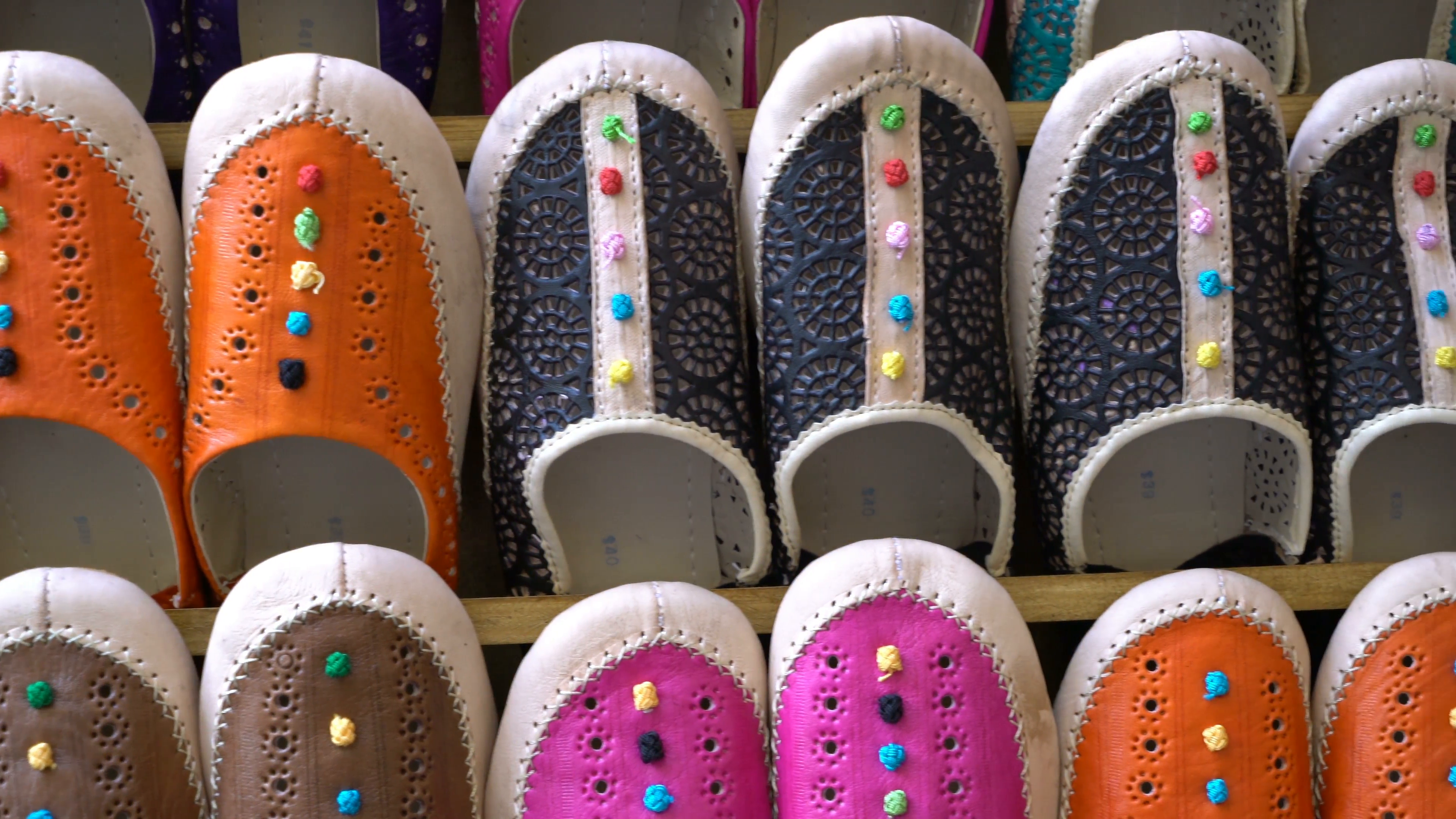 Left-right panning shot of colorful Arabic slippers for sale in the ...