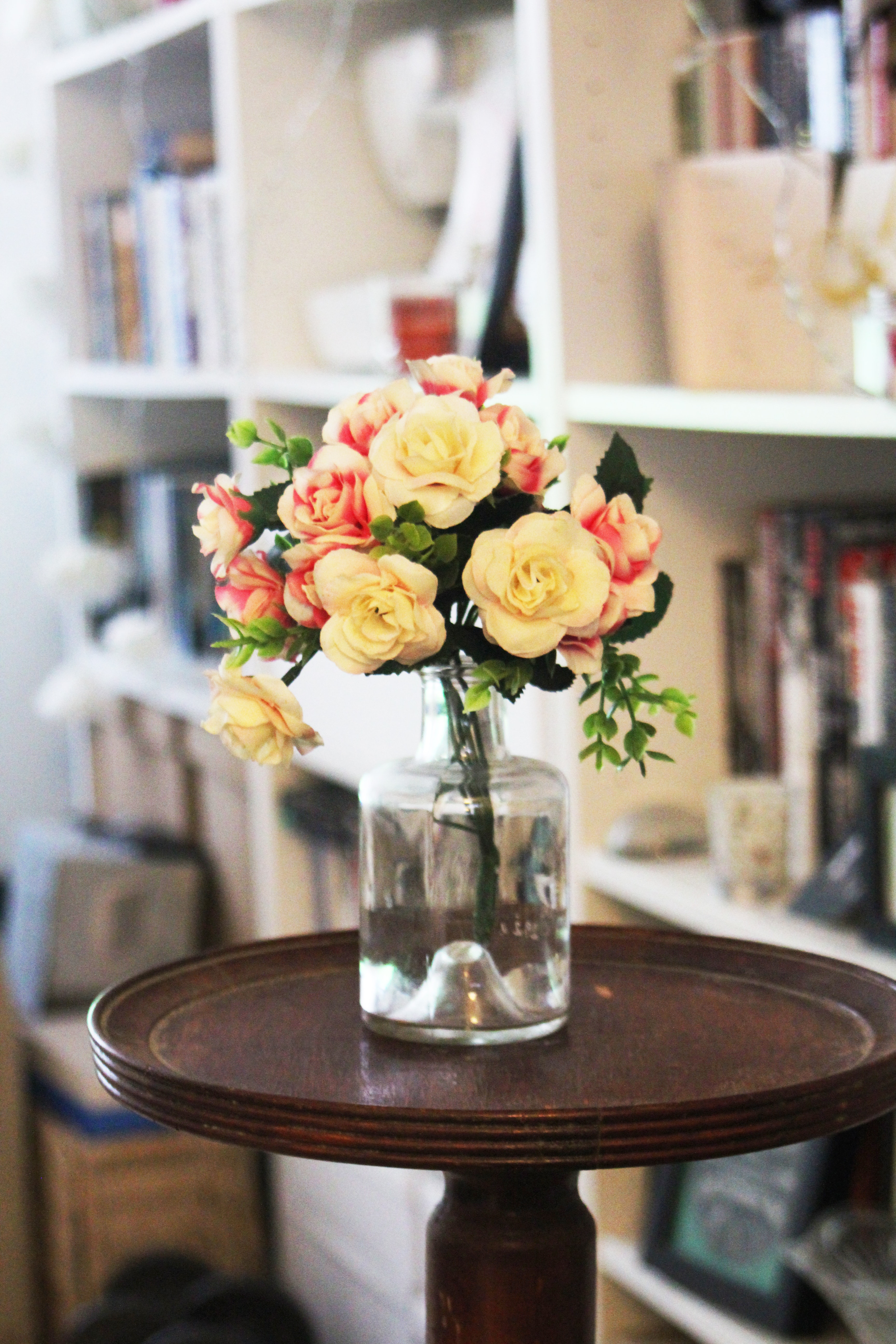 Arrange of petal flower in clear glass vase at table photo