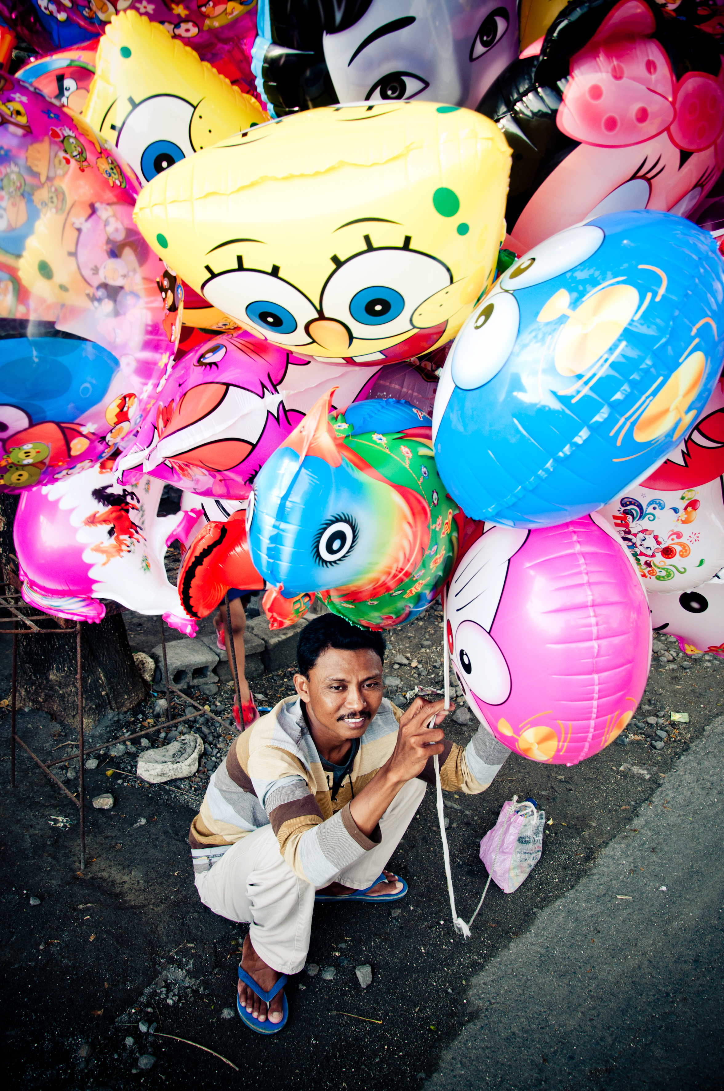 Asian man selling balloons in the street photo