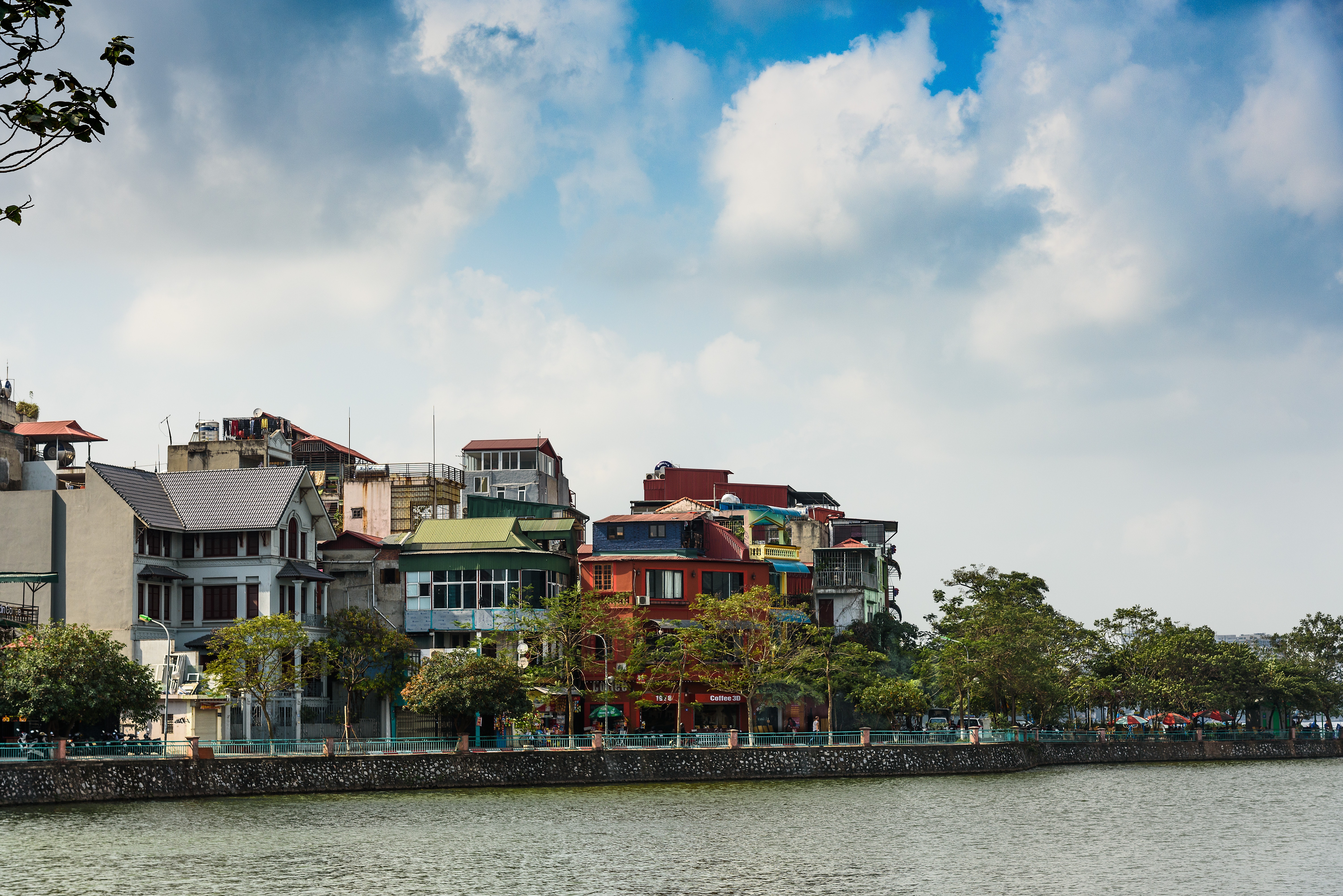 Assorted-color buildings near water and trees photo