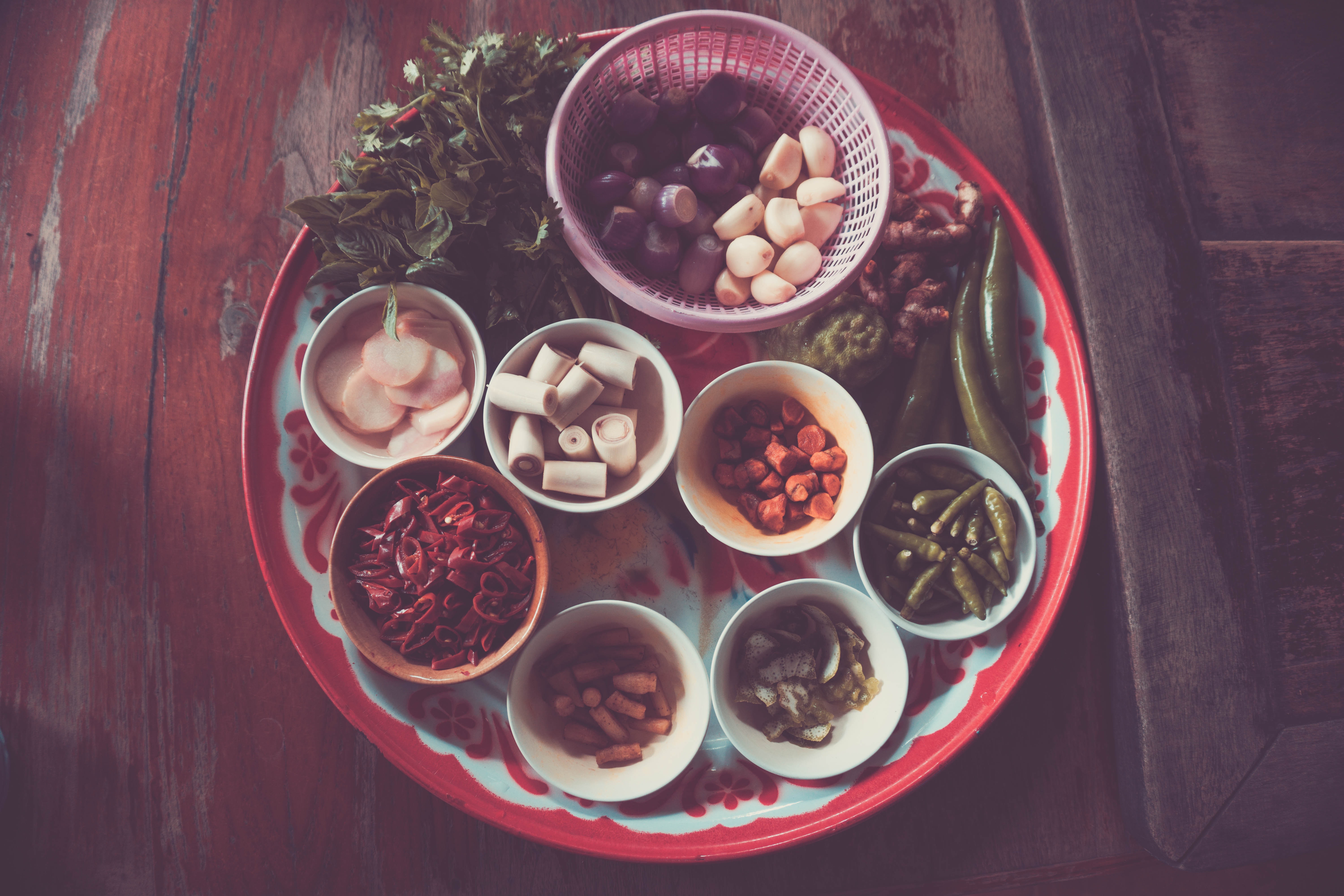 Assorted spices on white and red plate on brown wooden table photo