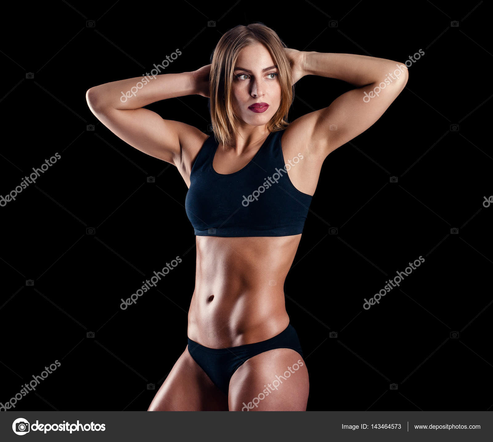 Sporty girl with great muscles in black sportswear. Tanned young ...