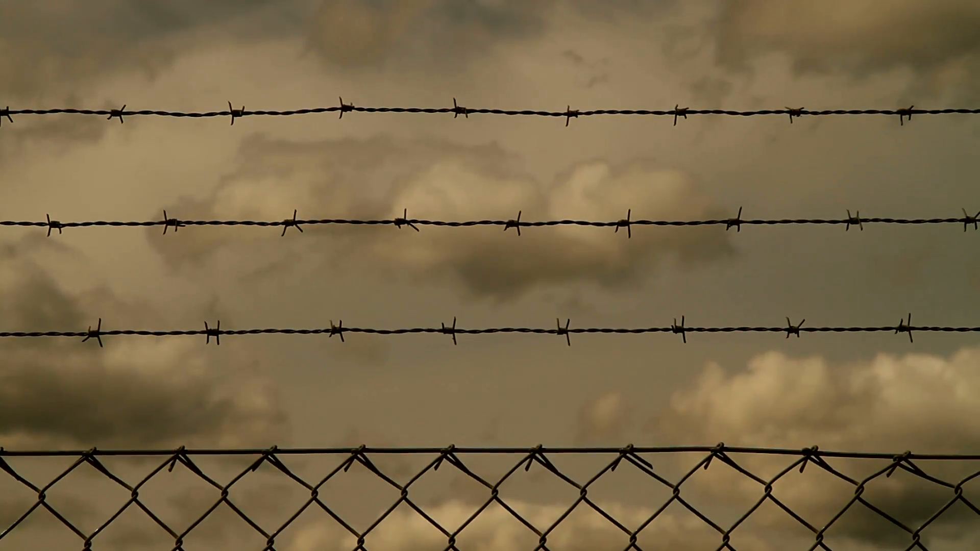 Fence with barbed wire against a cloudy background Stock Video ...