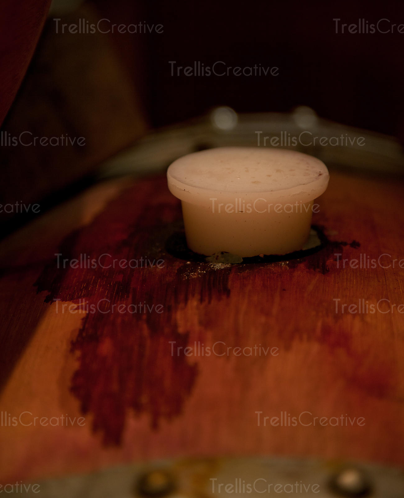 Trellis Creative | Close-up of a bung in a wine stained oak barrel ...