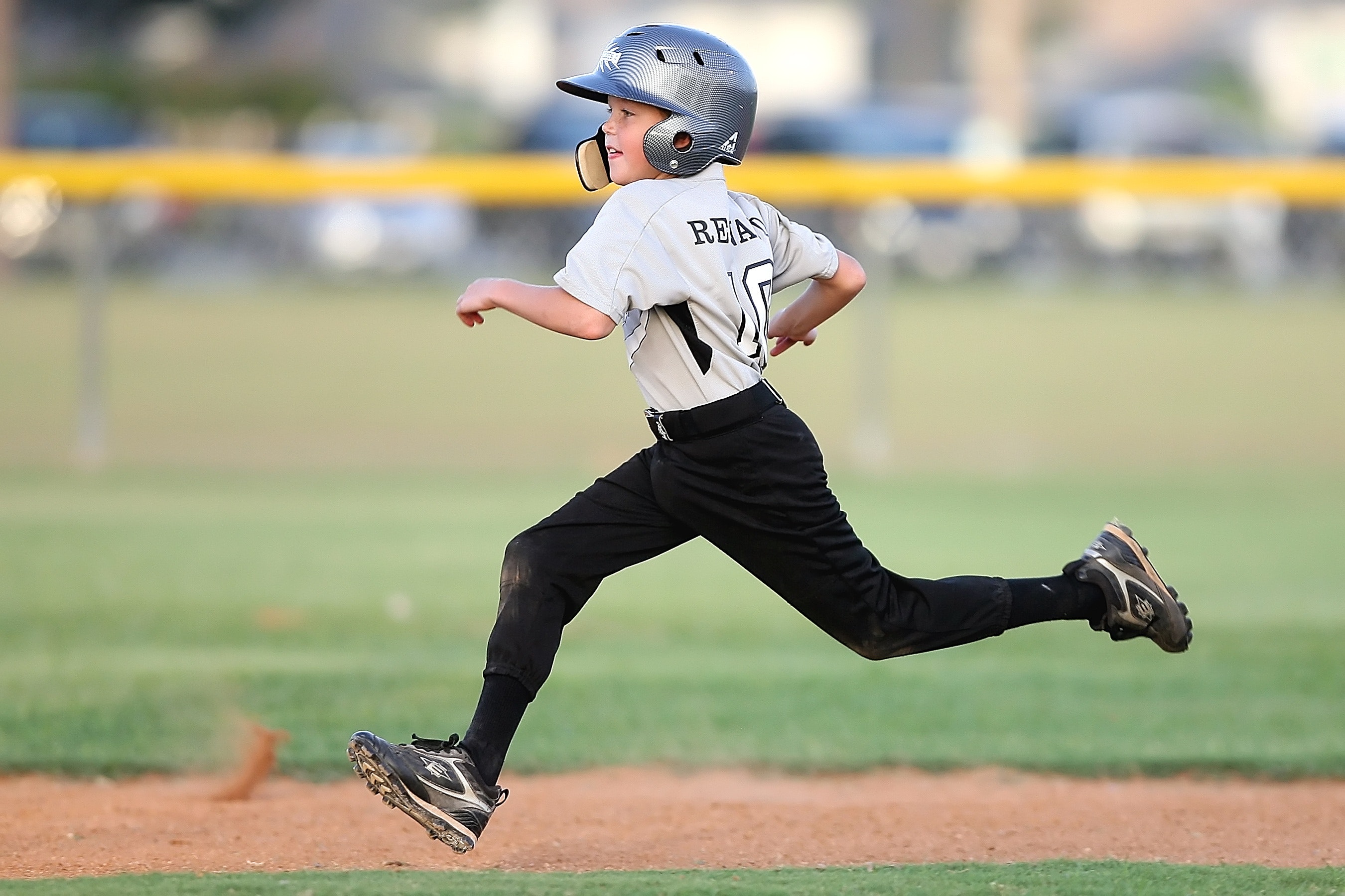 Baseball player in gray and black uniform running photo
