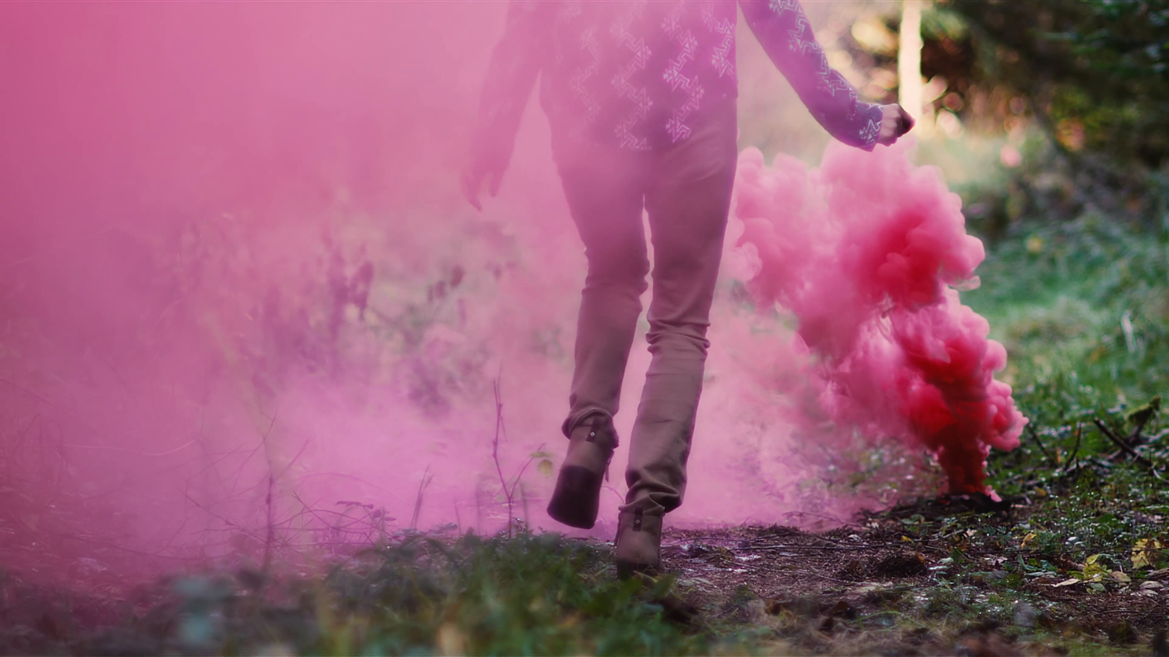Beautiful girl in a forest runs through pink smoke from a color ...