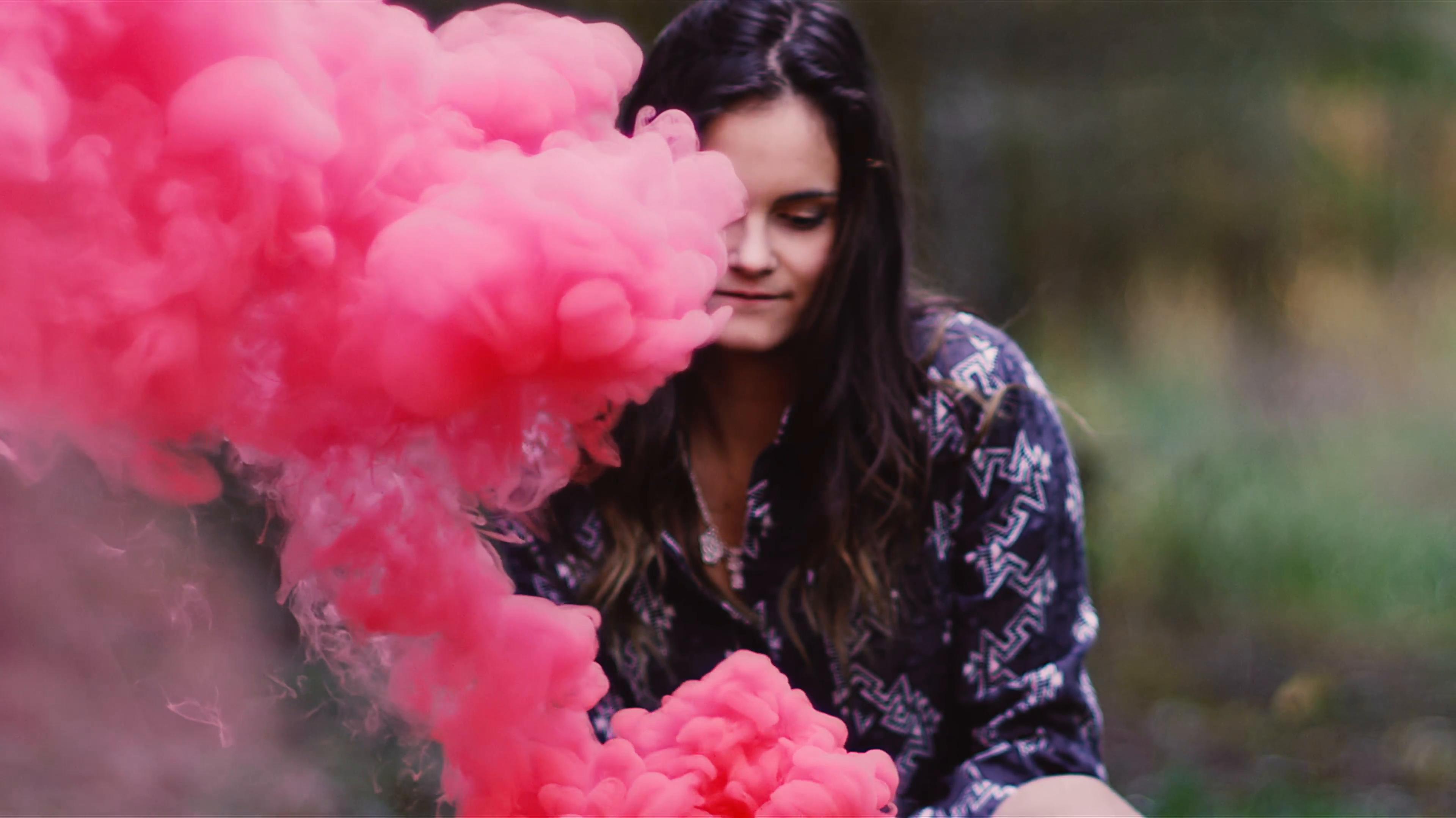 Beautiful girl in a forest waves around a color smoke grenade, slow ...
