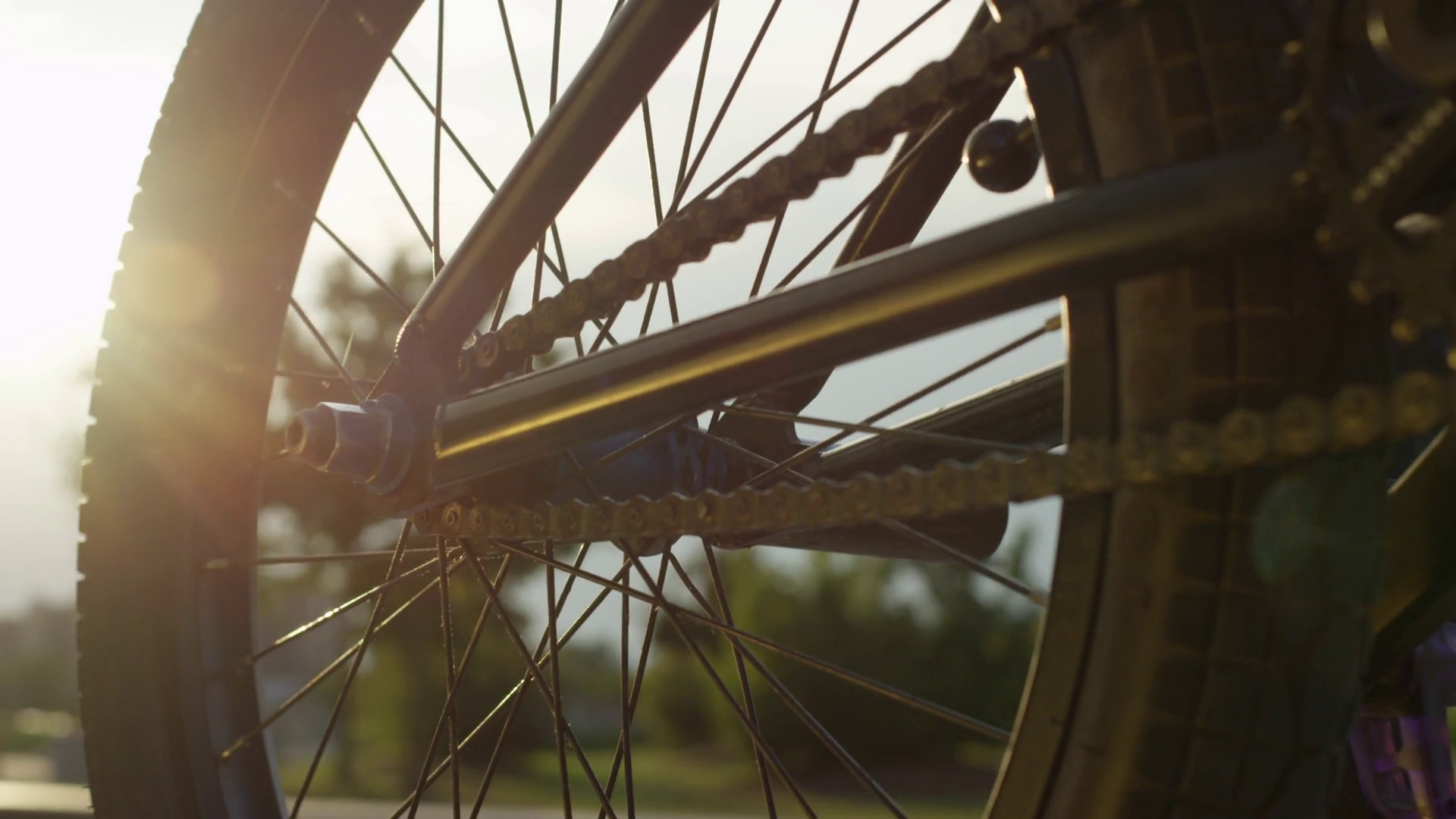 EXTREME CLOSE UP: Sun shining through bmx bike wheel, biker spinning ...