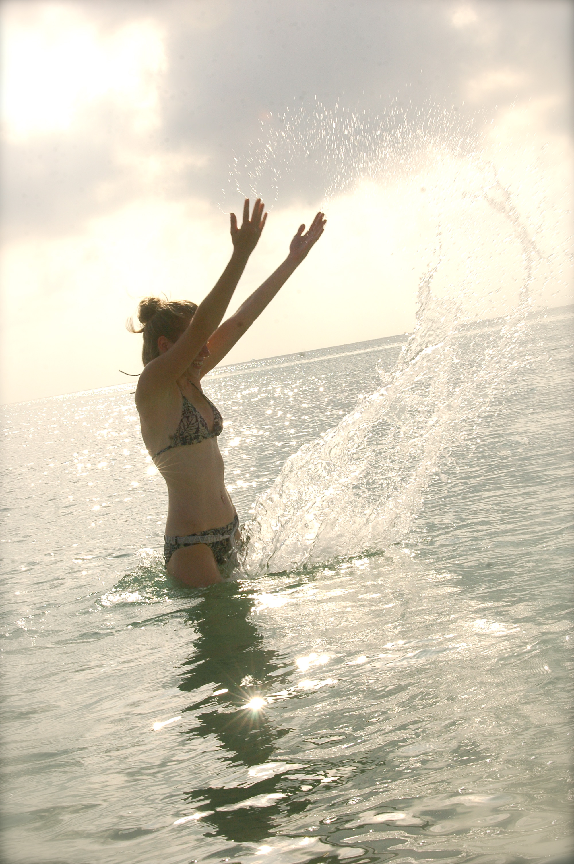 Bikini girl splashes water in the ocean photo