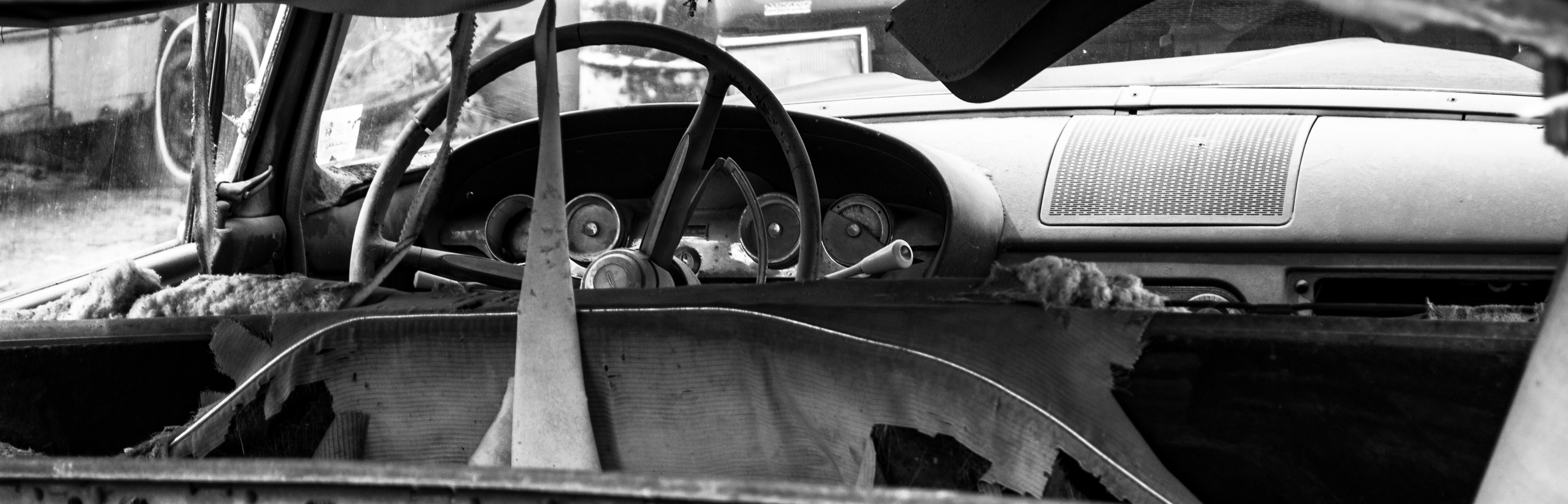 Black and white photo of an abandoned car dashboard