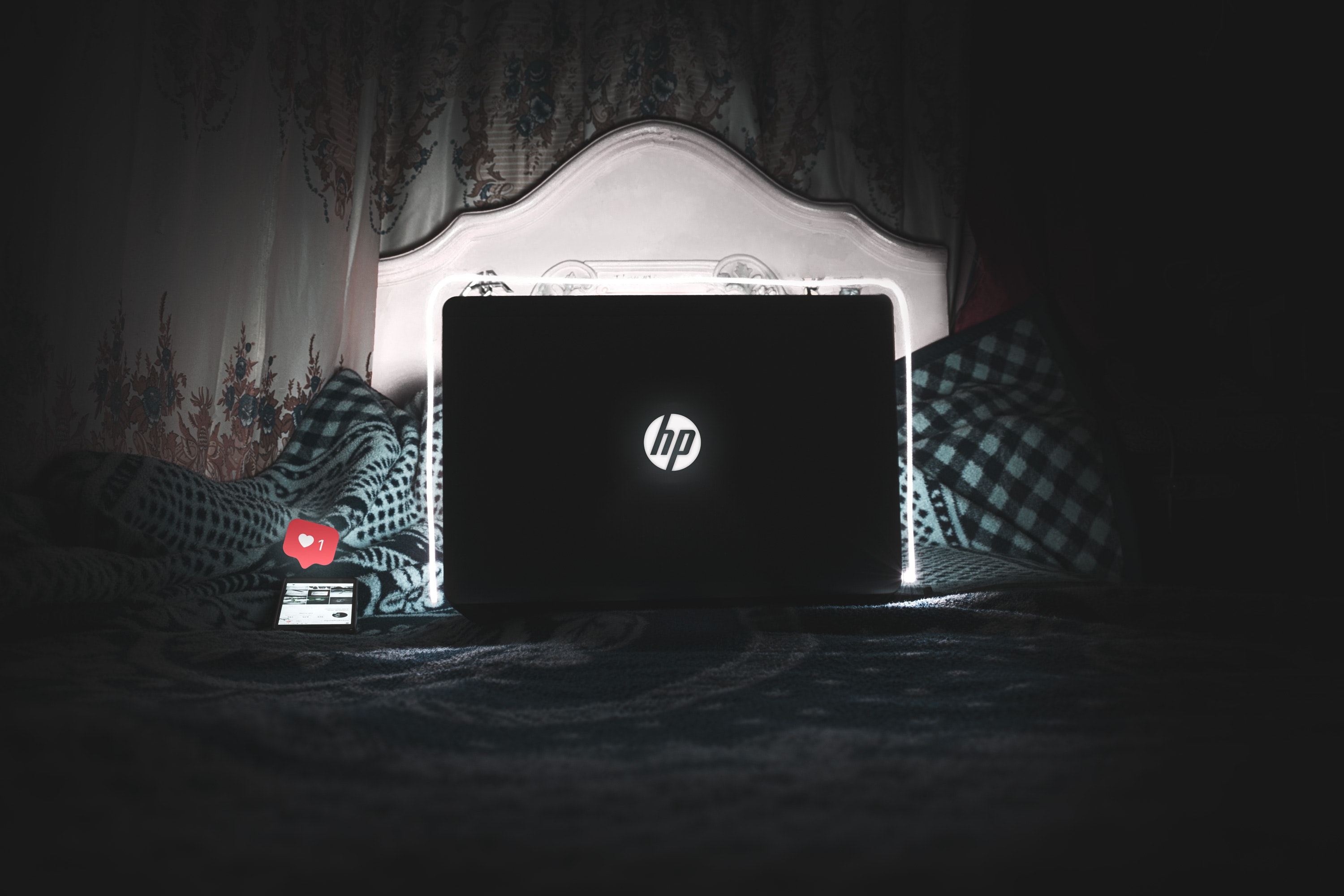 Black hp laptop on bed is on photo