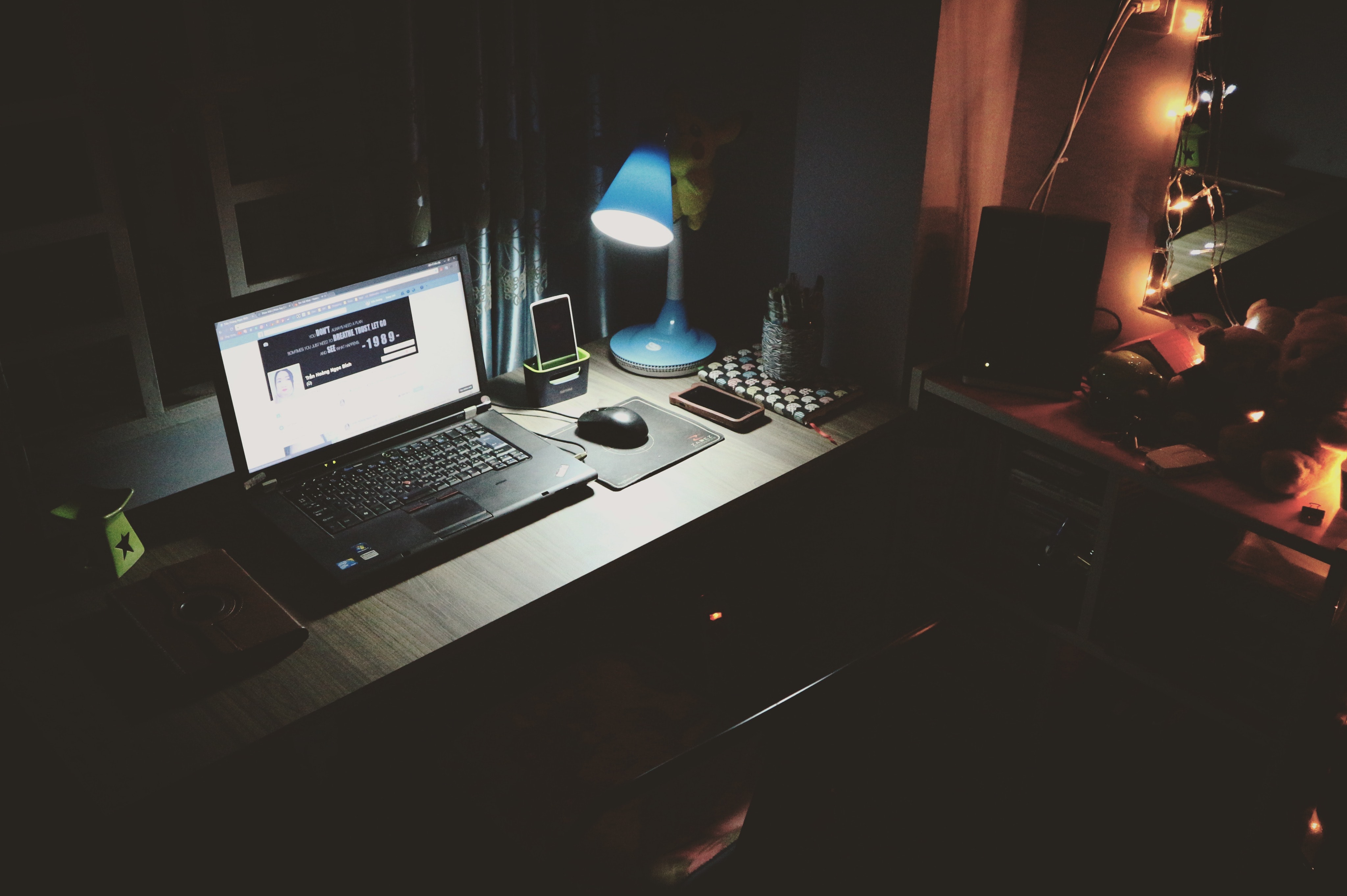 Black laptop beside black computer mouse inside room photo