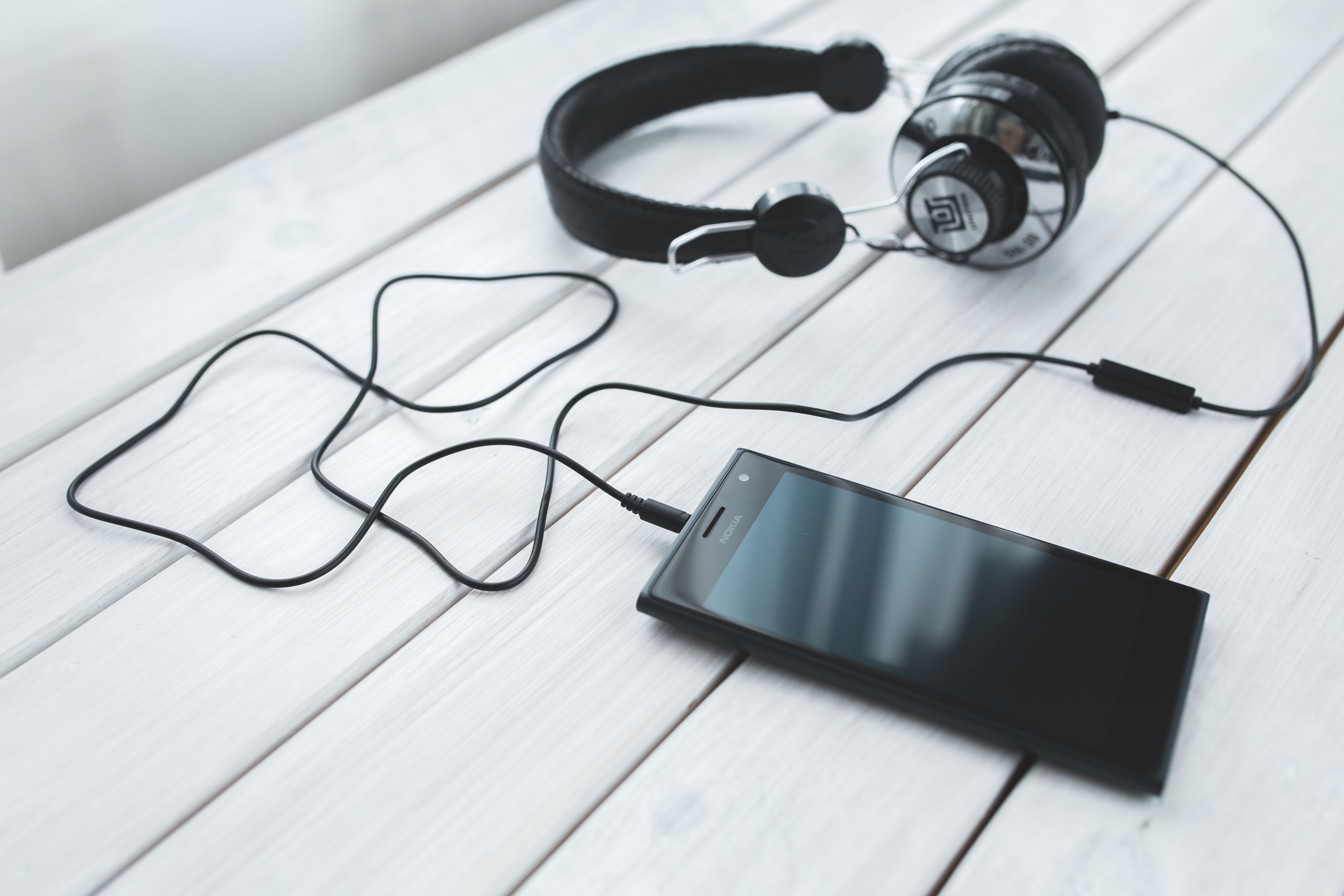 Black smartphone and headphones on a desk photo