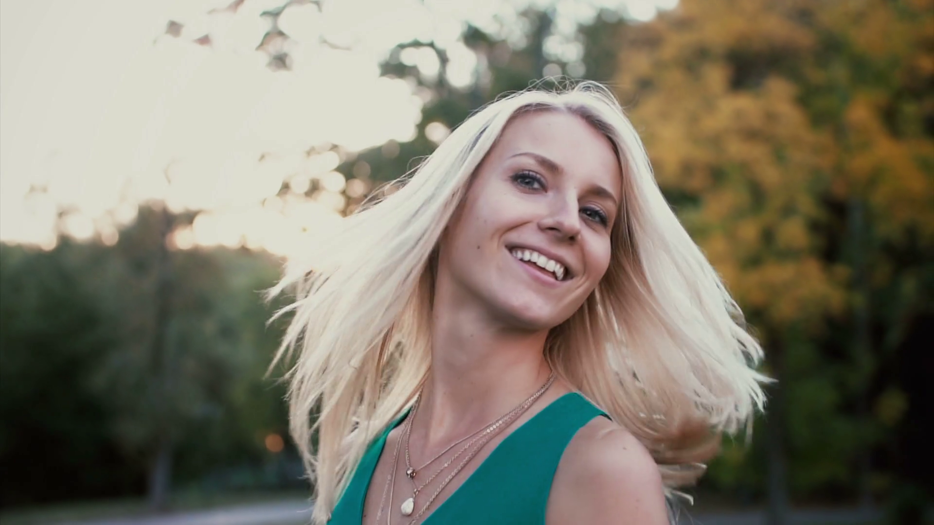 Portrait of beautiful young woman in park on sunset. Blonde girl ...