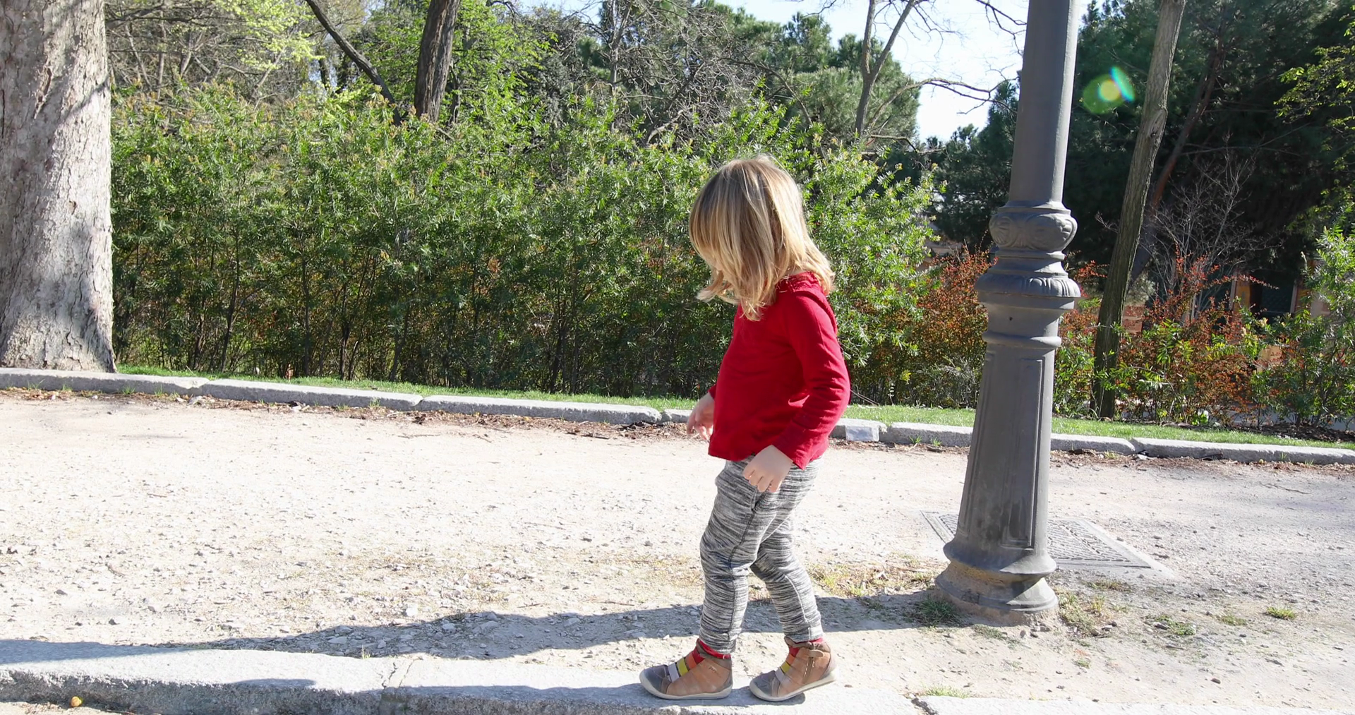 side view of three years old blonde child, with red shirt and grey ...