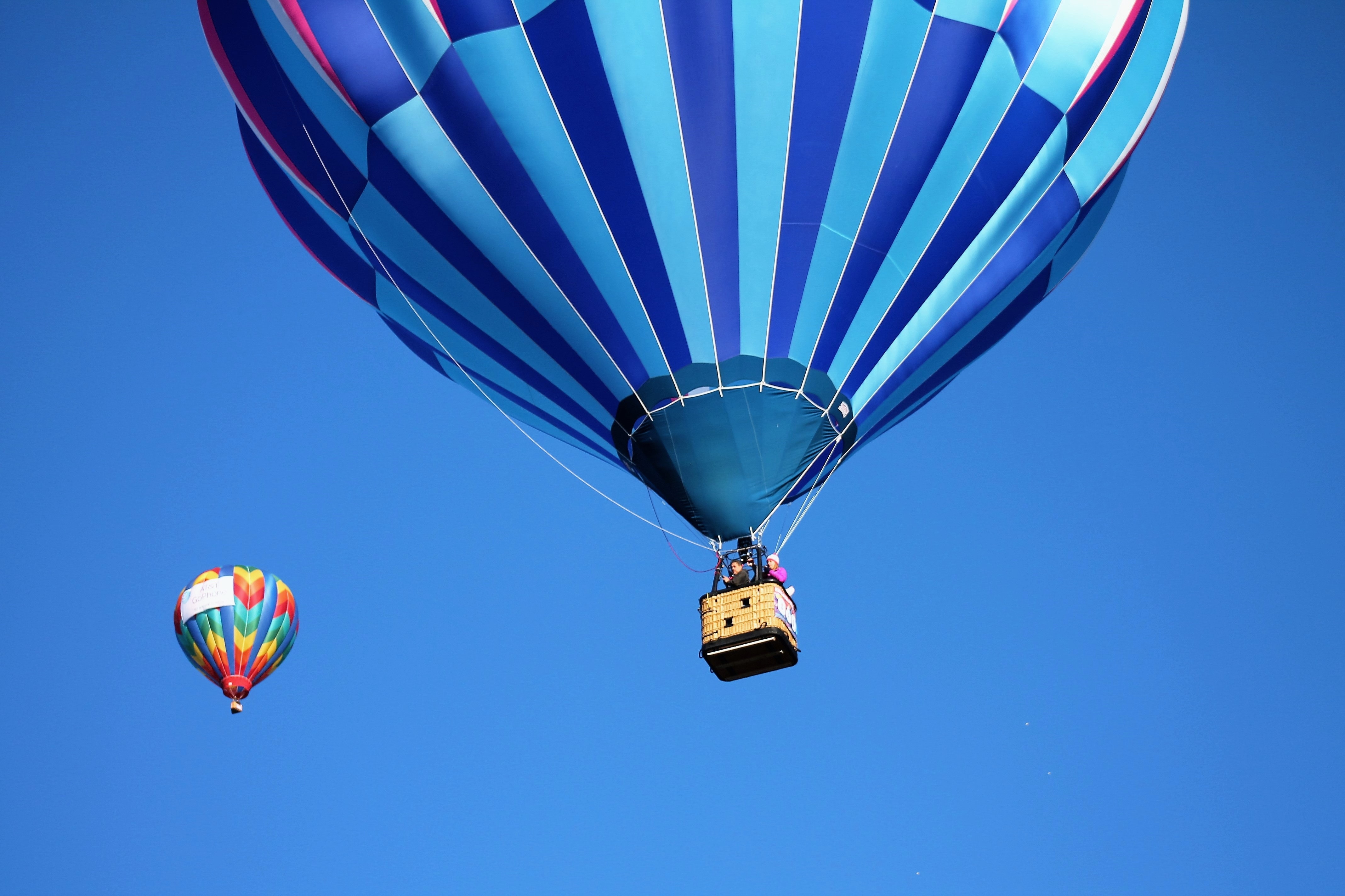 Blue and teal hot air balloon near pink and blue hot air balloon photo