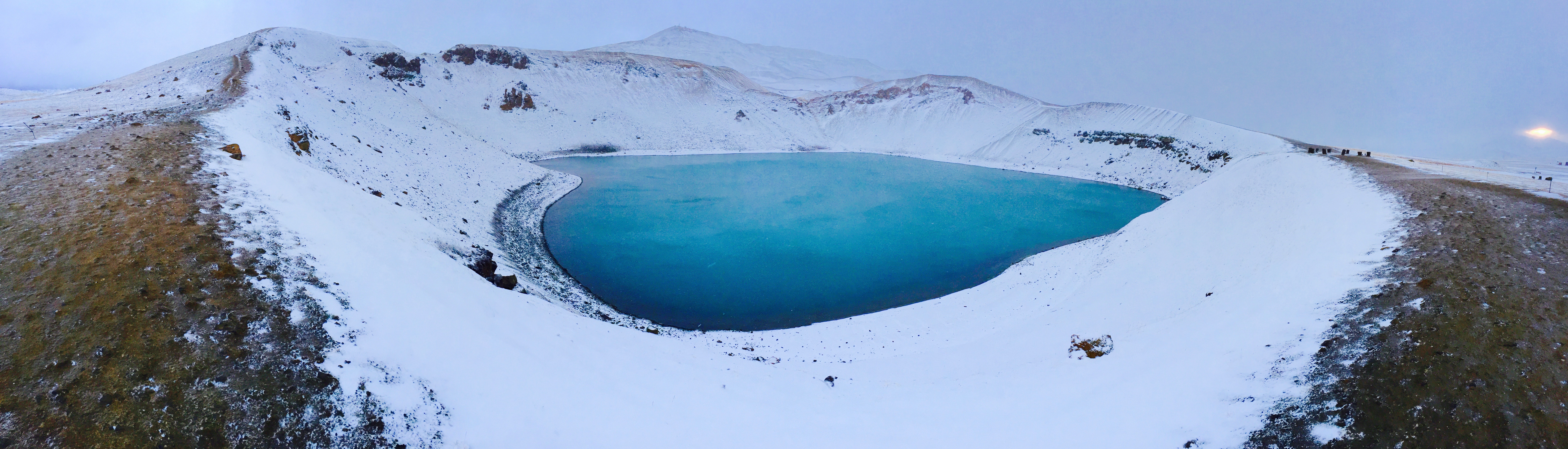 Blue lake in the middle of snowfield photo