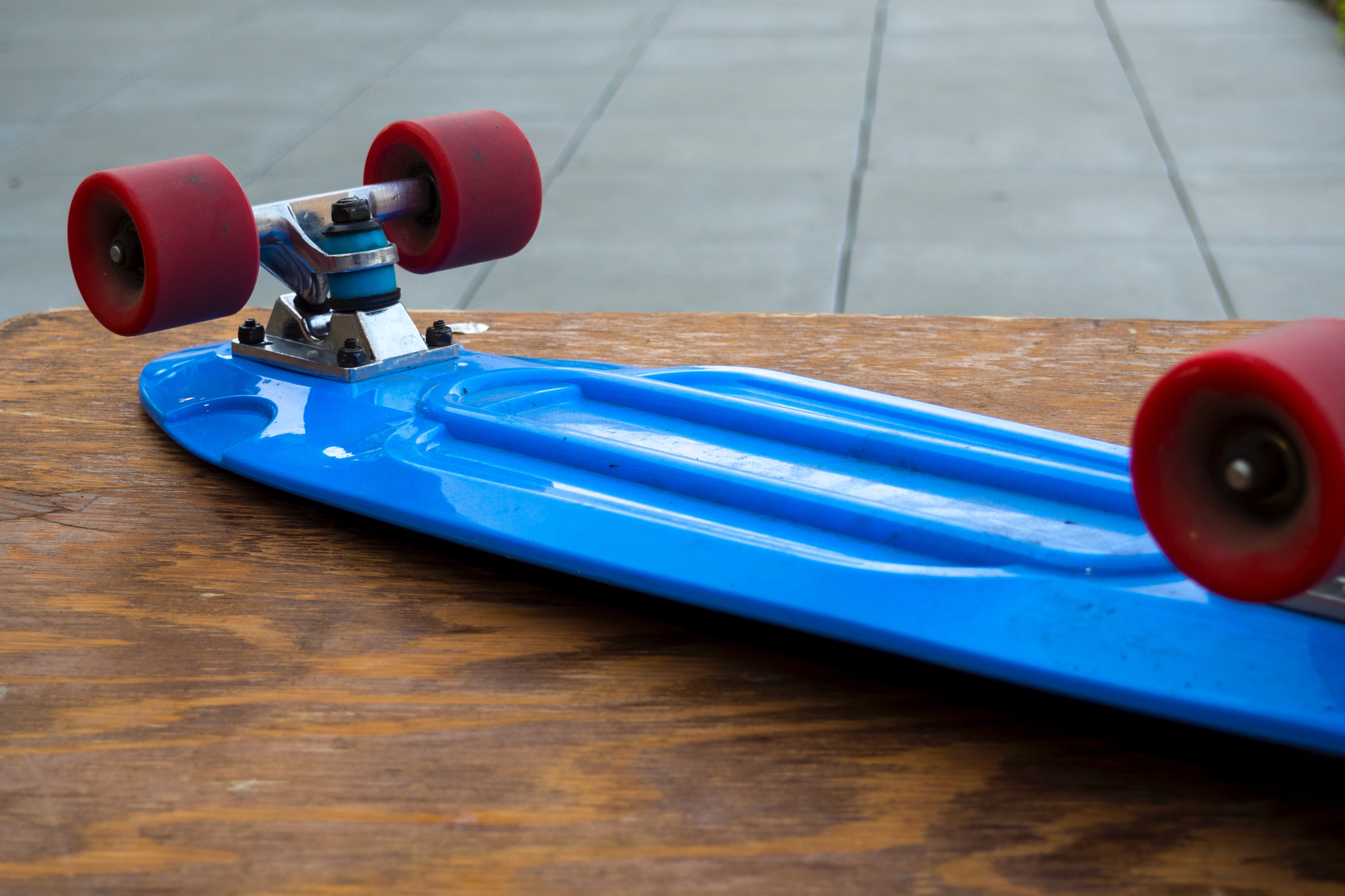 Blue penny board on wooden table photo