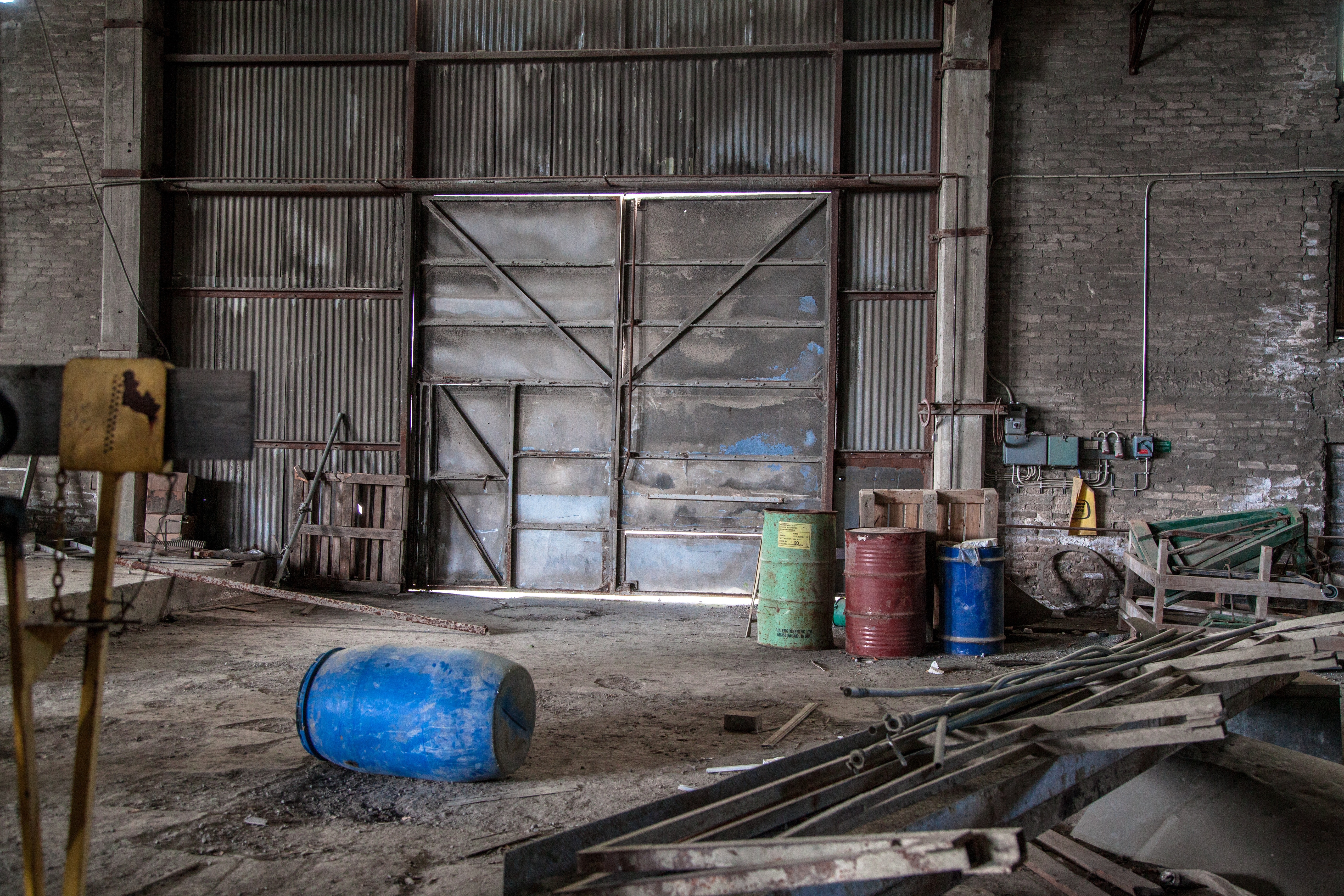 Blue plastic barrel on floor surrounded by metal pipe inside warehouse photo
