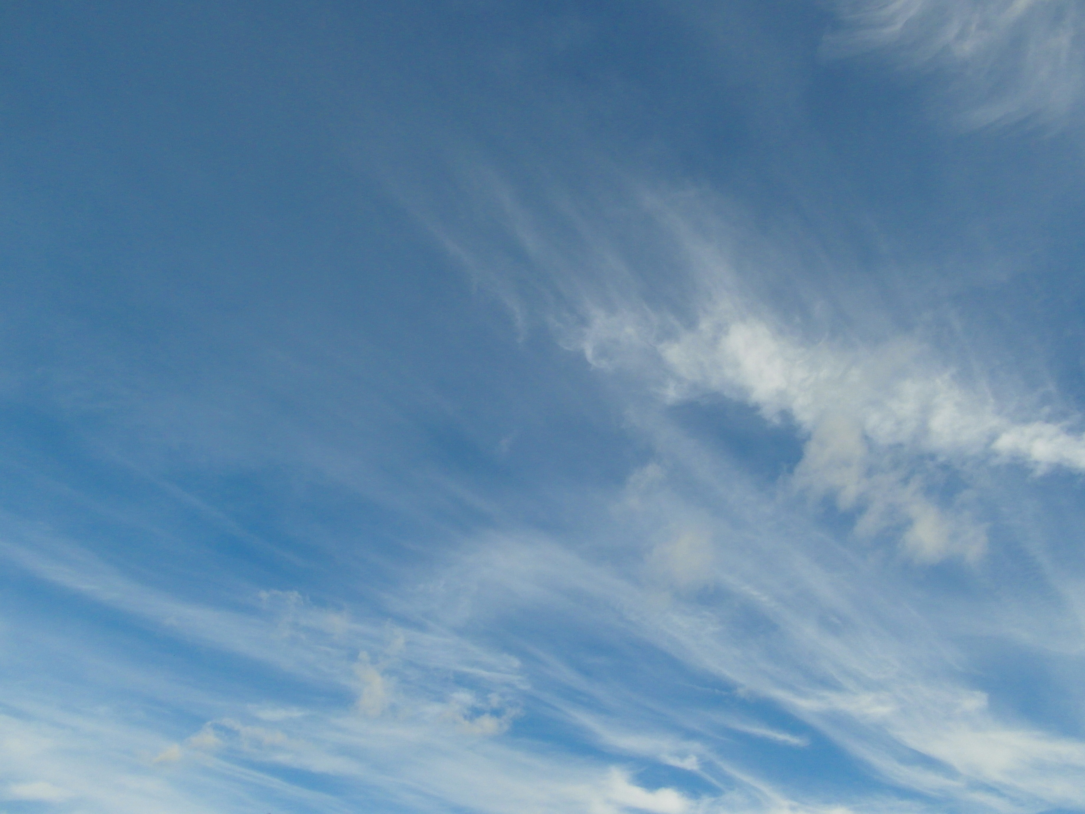 Blue sky wispy clouds background photo