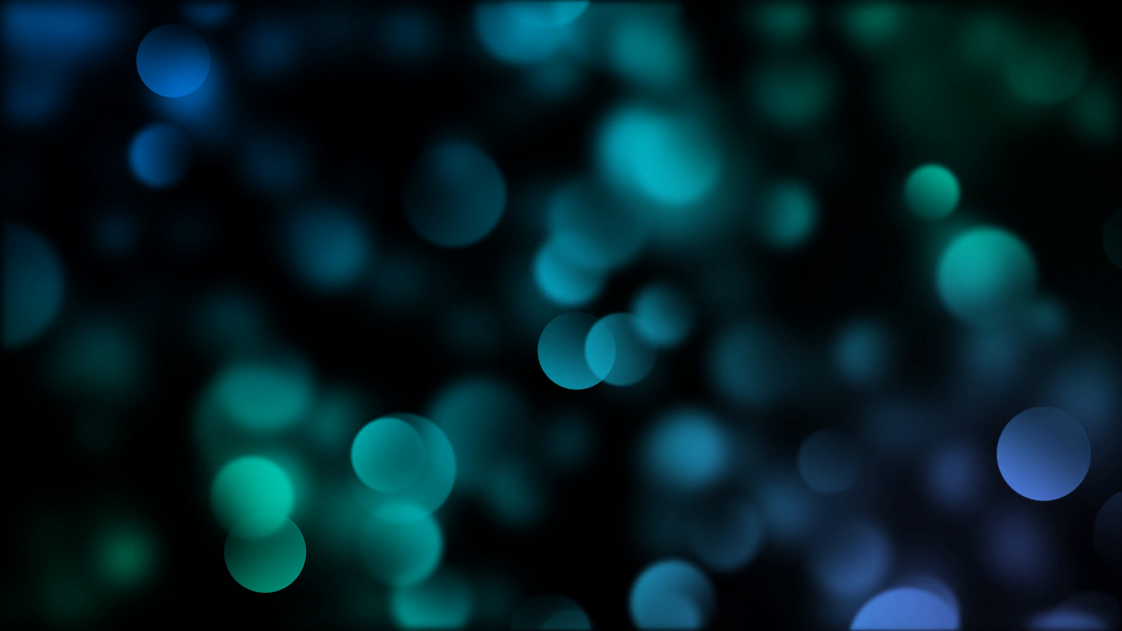 Blue and turquoise blurred bokeh particles slowly float right on a ...