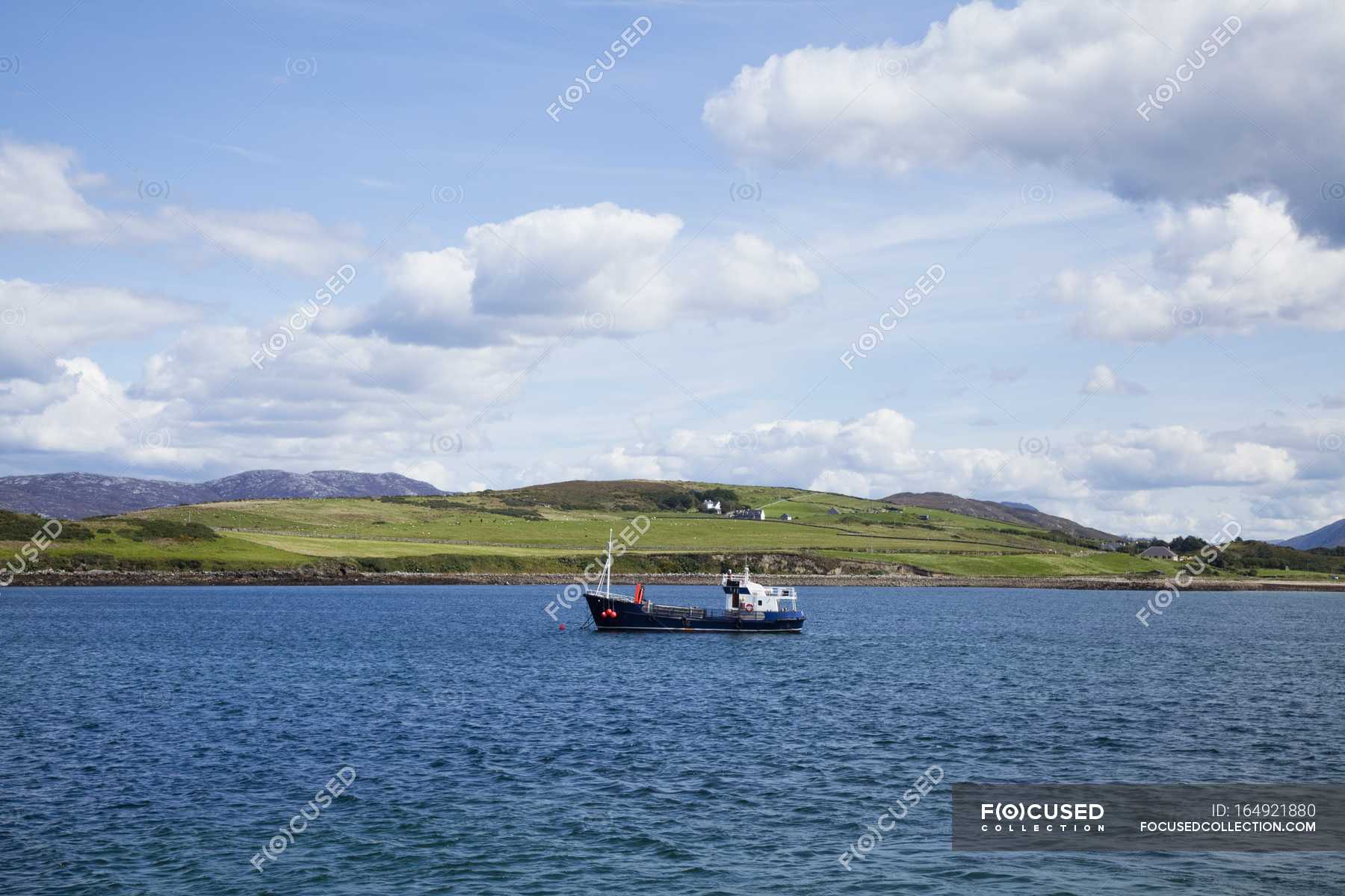 Boat in water against coast — Stock Photo | #164921880