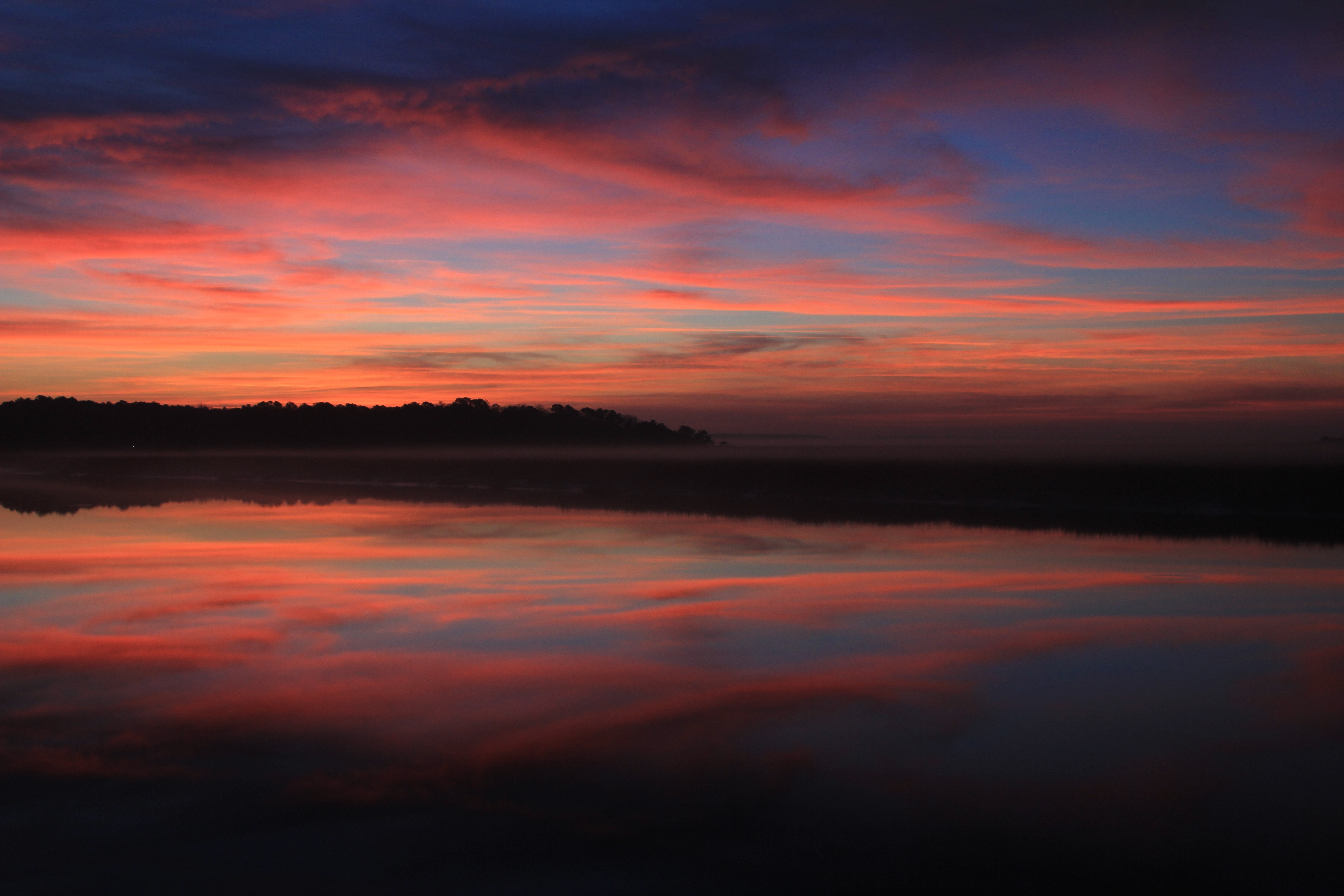 Body of water under blue red and yellow sunset sky photo
