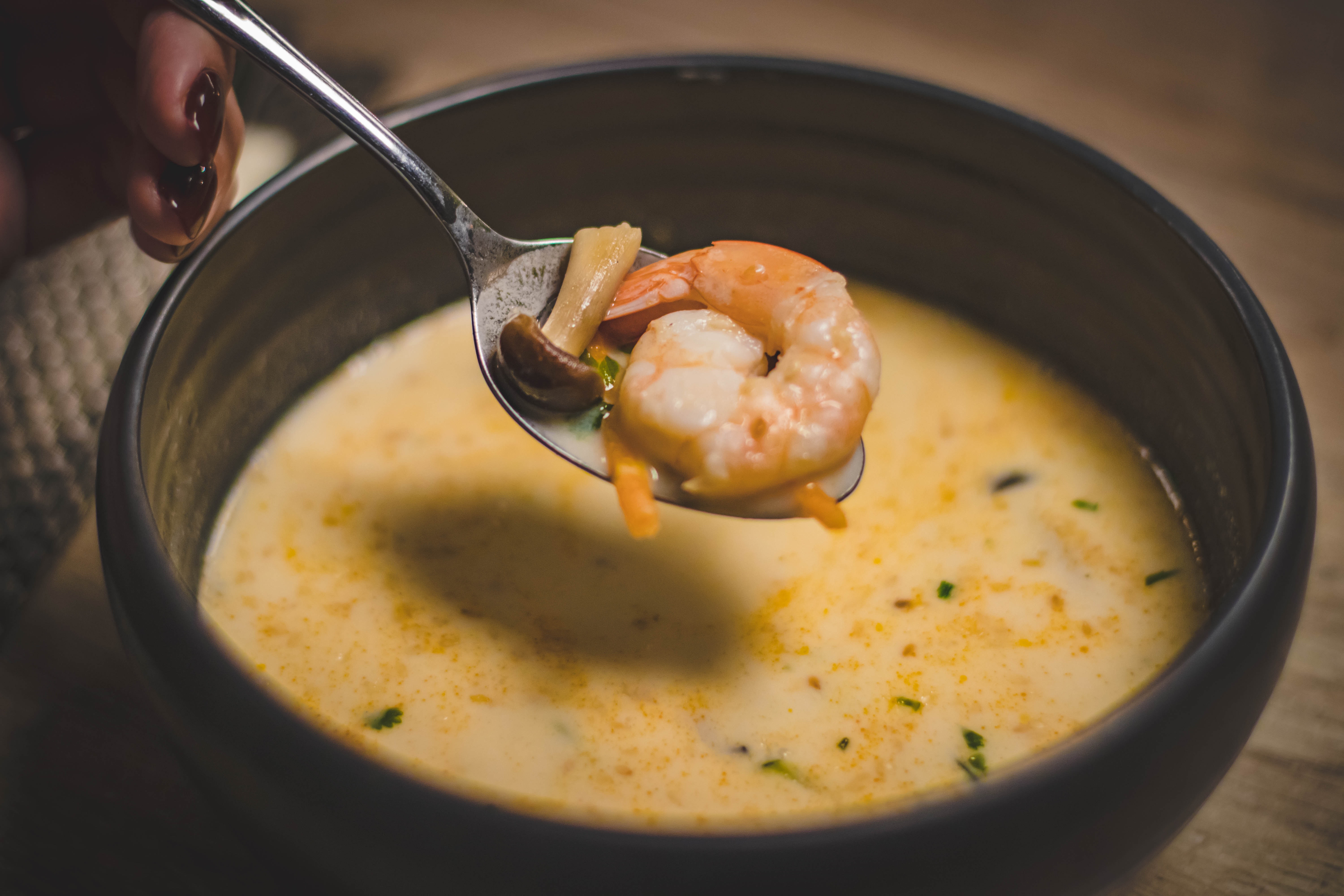 Bowl of shrimp soup on brown wooden surface photo