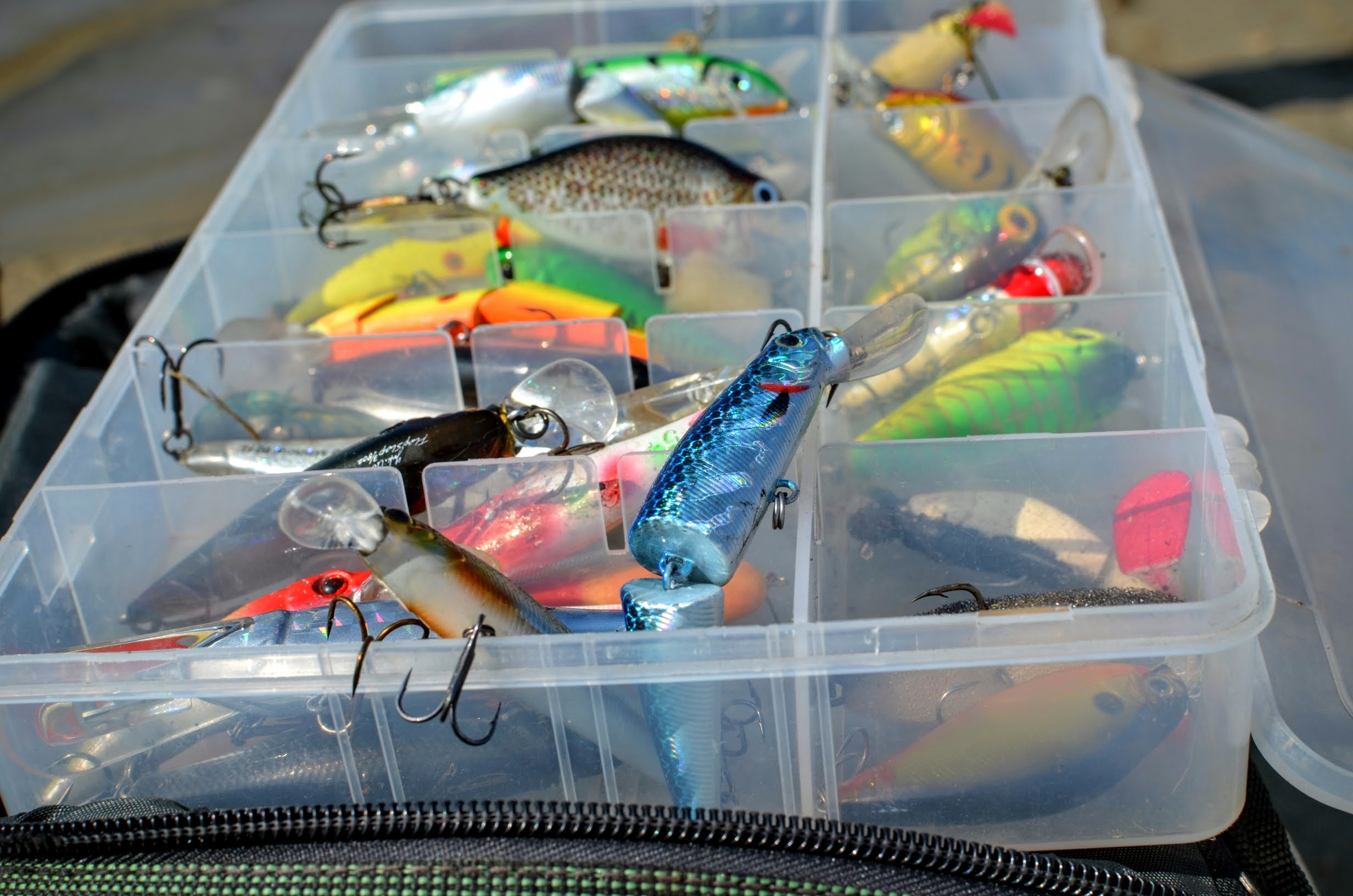 Box with lures lies on the fishing bag photo