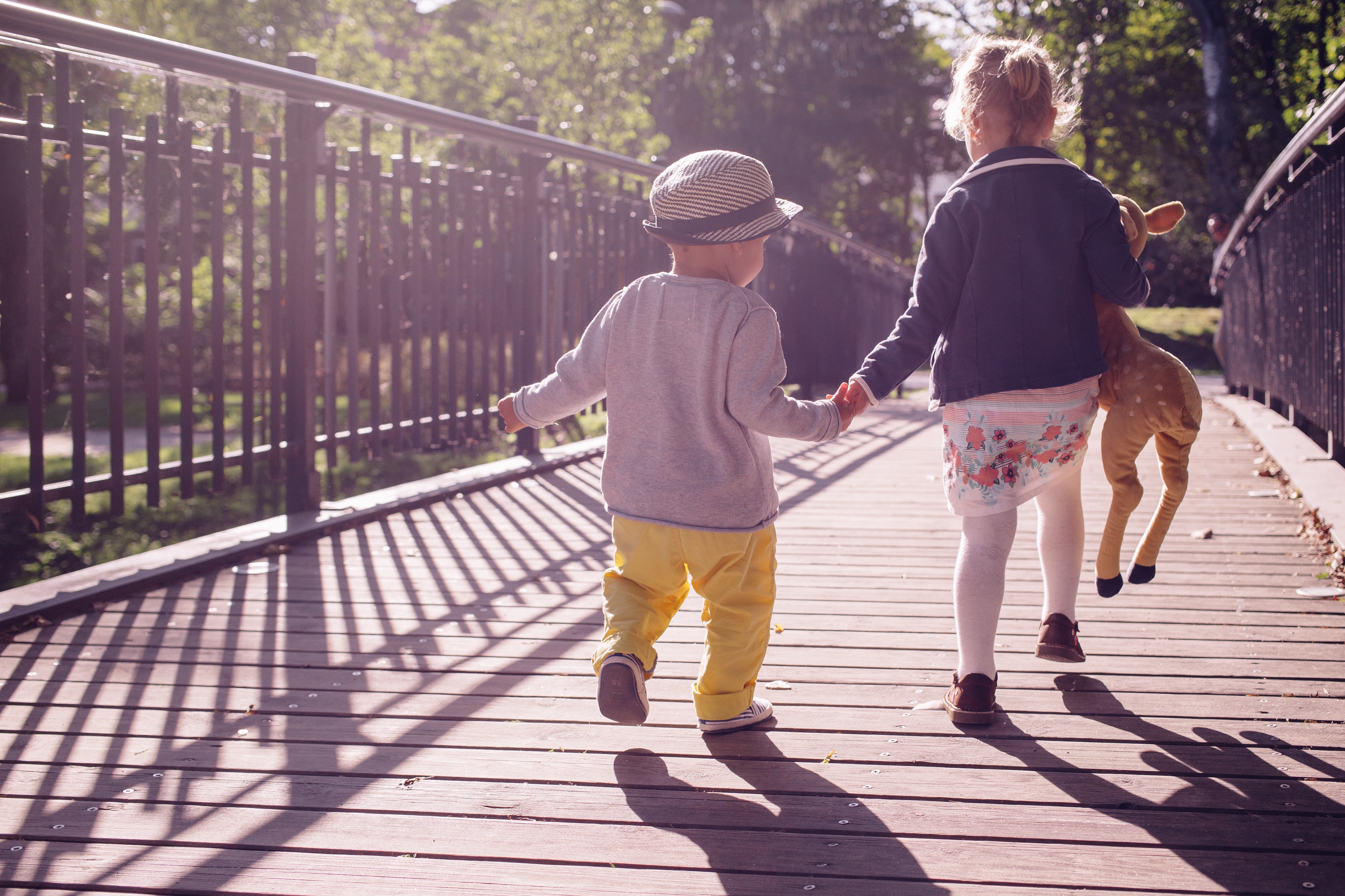Boy and girl walking on bridge during daytime photo