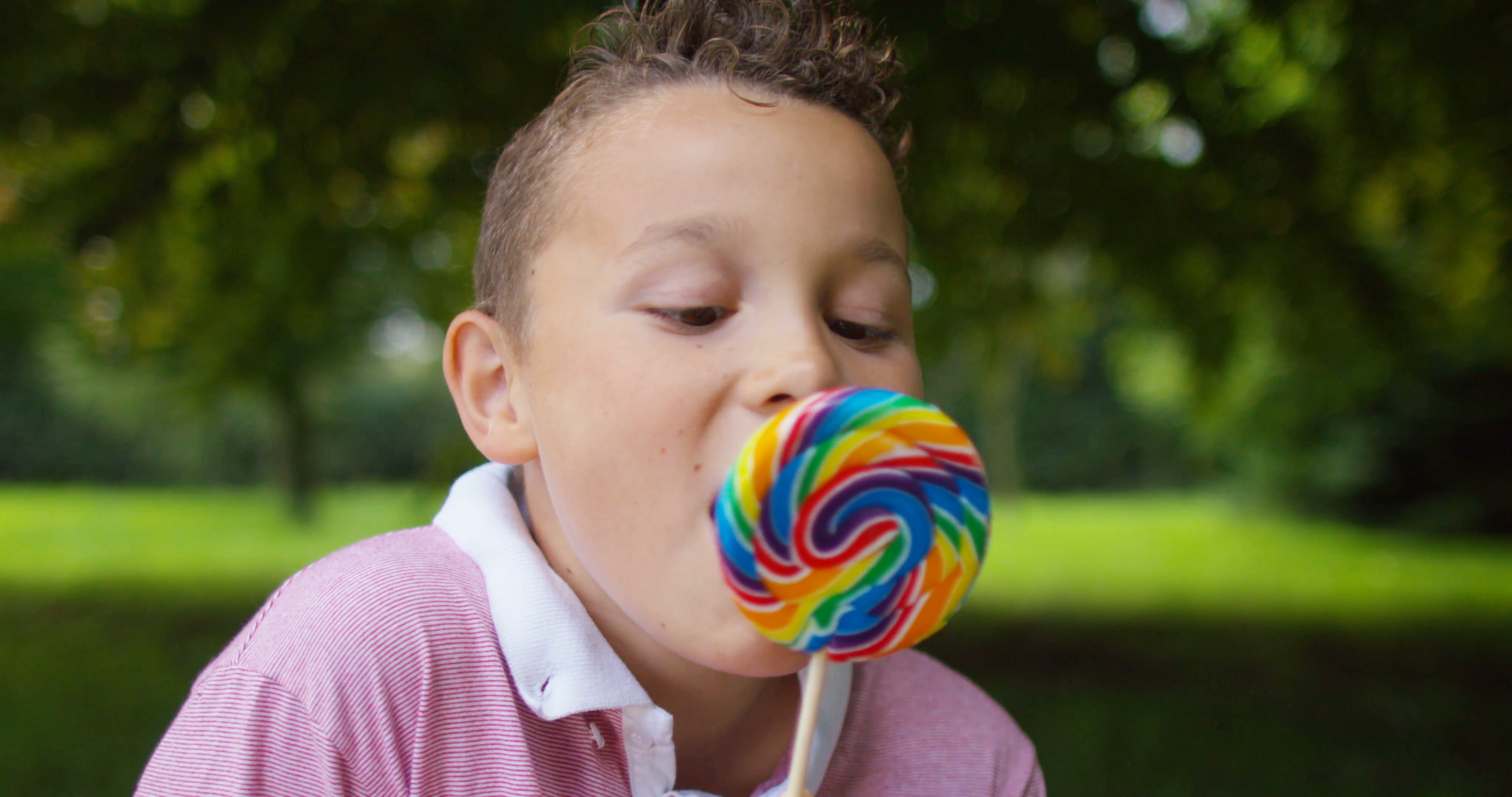 4K Portrait of happy little boy eating lollipop outdoors Stock Video ...