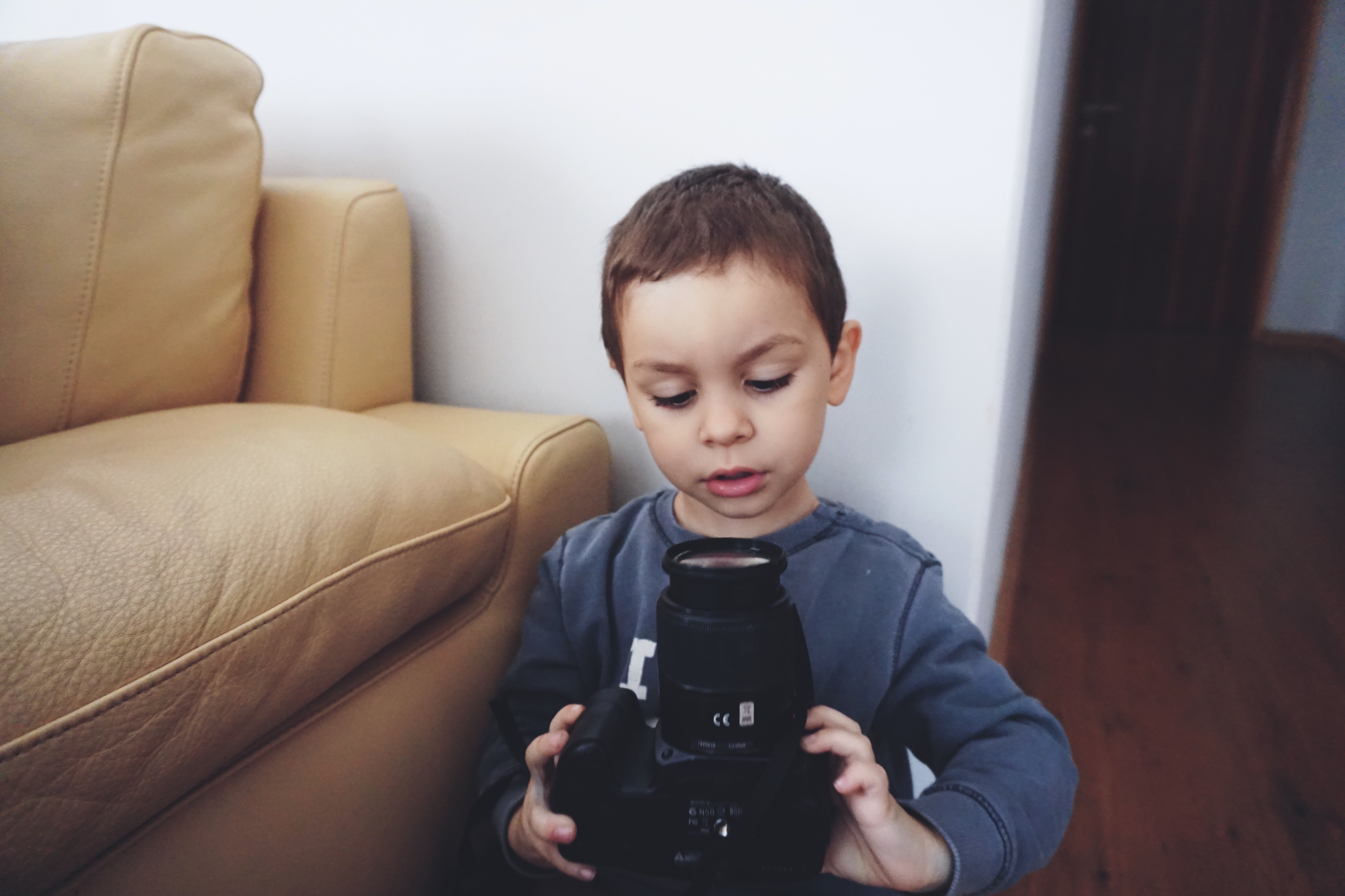 Boy holding black dslr camera photo