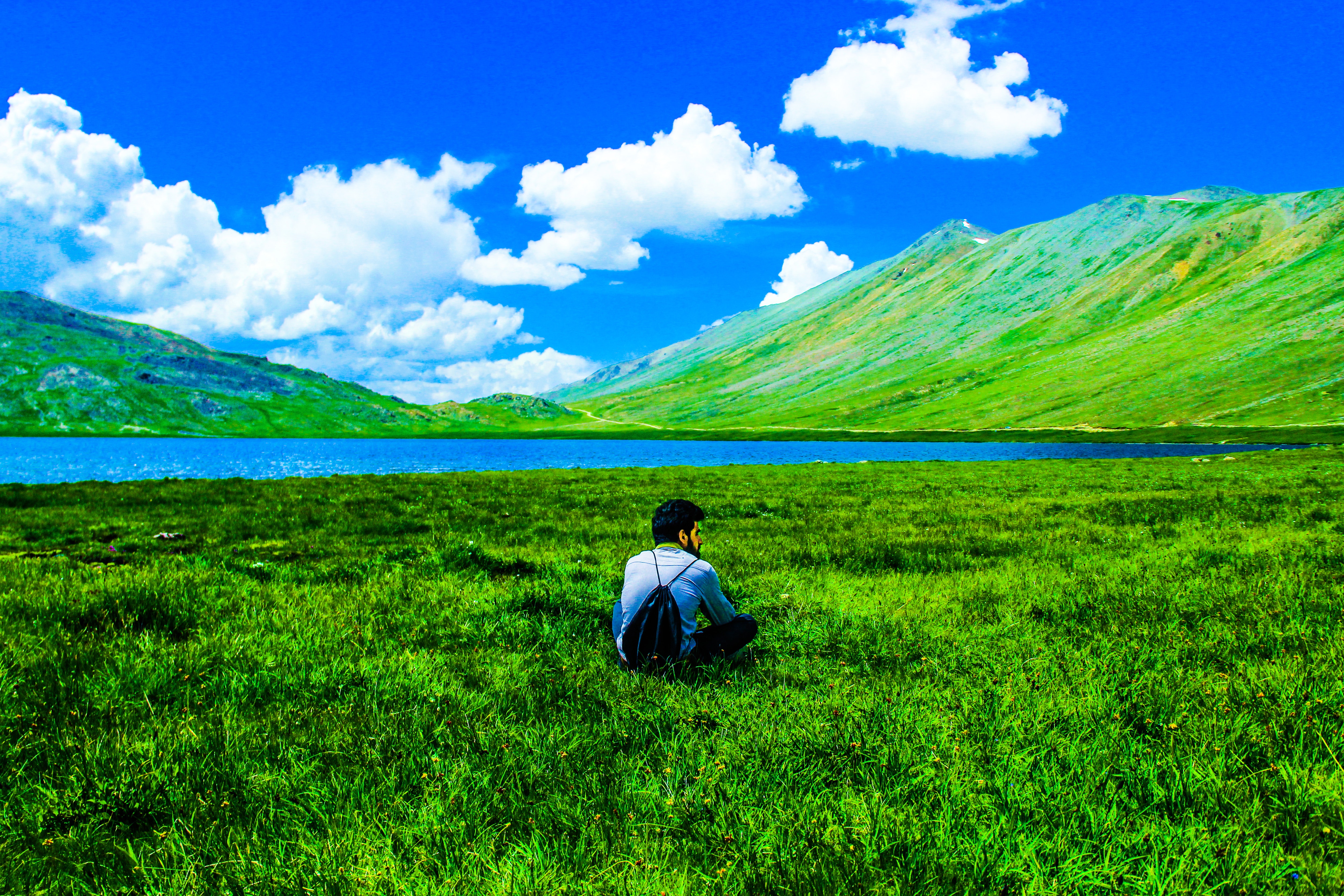 Boy sitting on green grass field photo