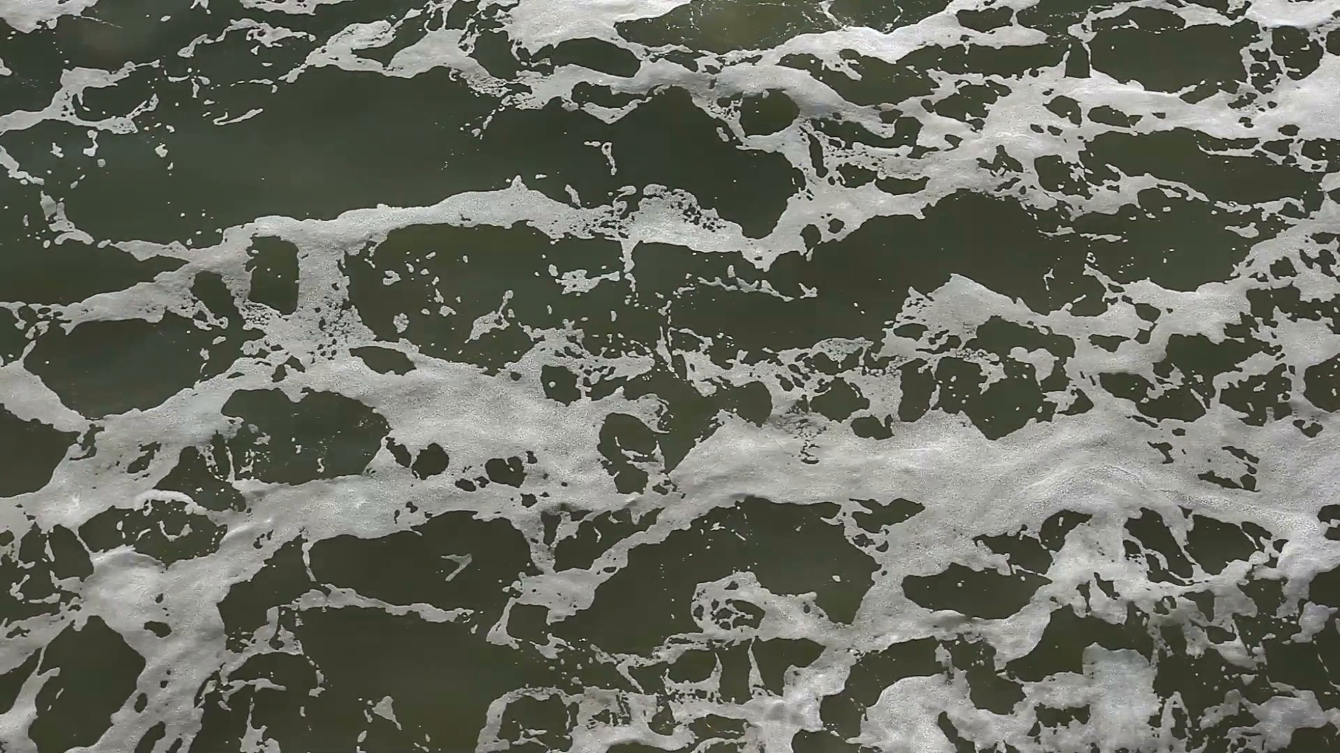 Breaking waves leave behind sea foam Stock Video Footage - Videoblocks